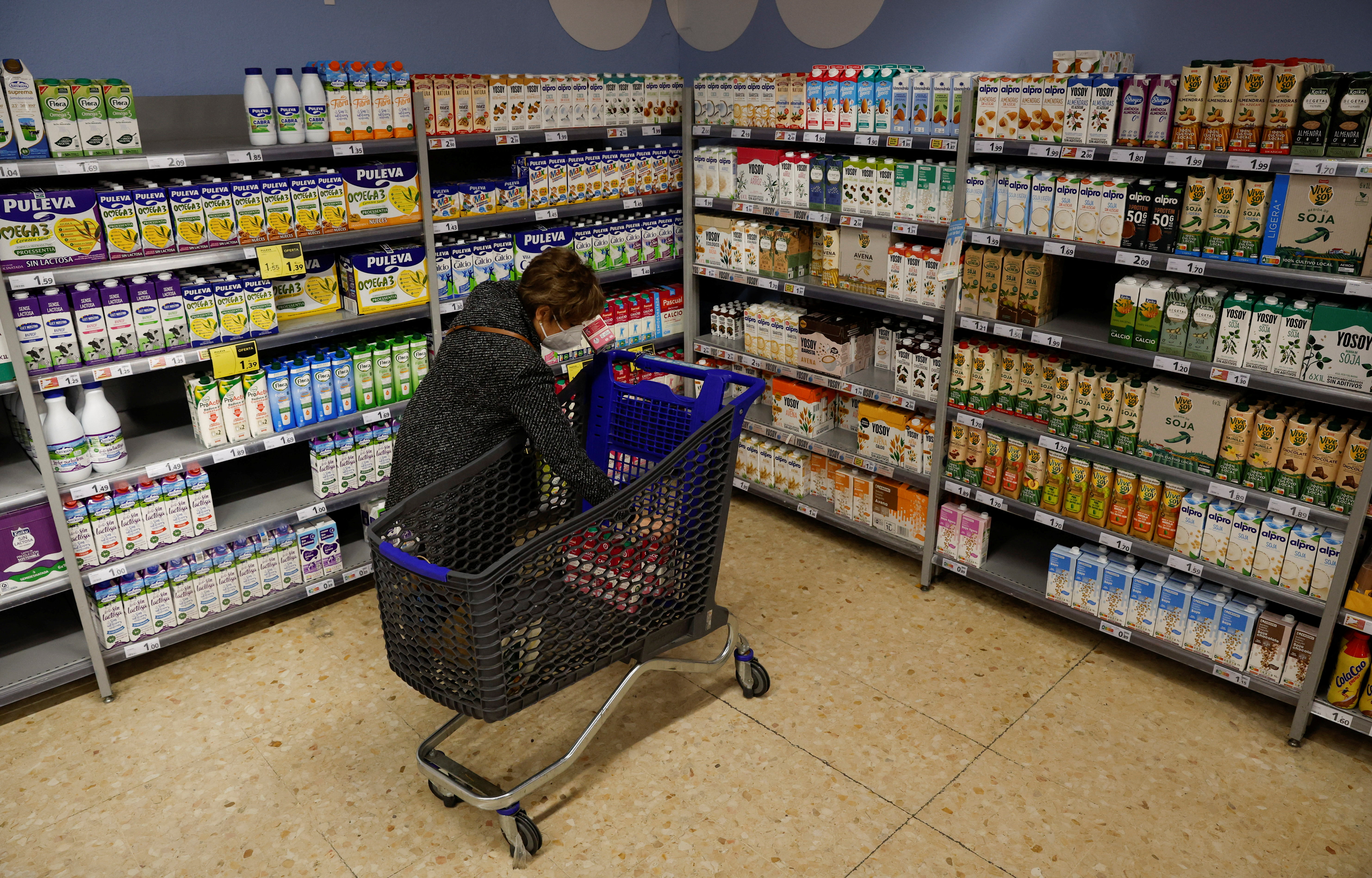 A woman takes some milk in a Caprabo supermarket in Barcelona