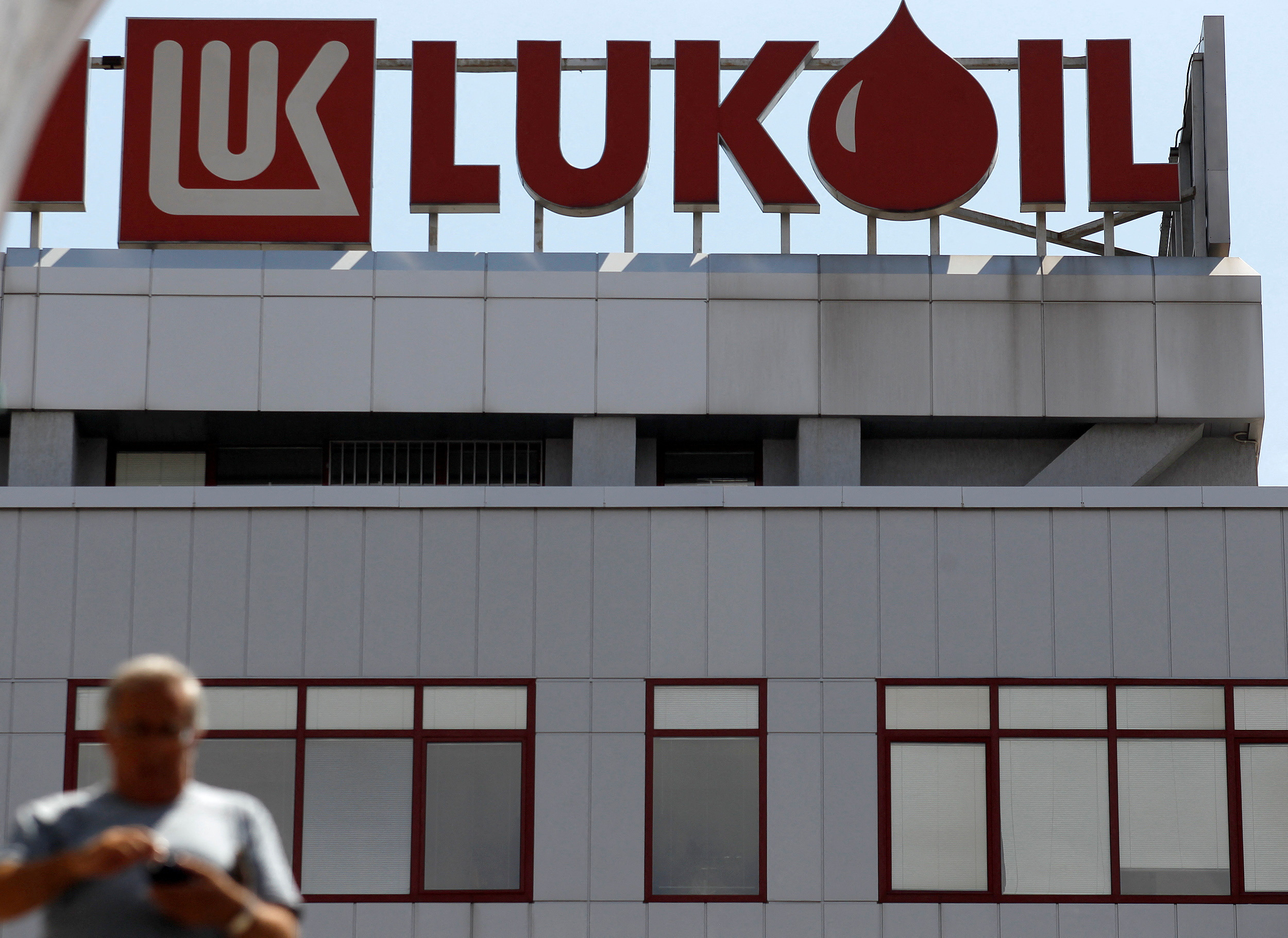 Man walks in front of LUKOIL's headquarters in Sofia