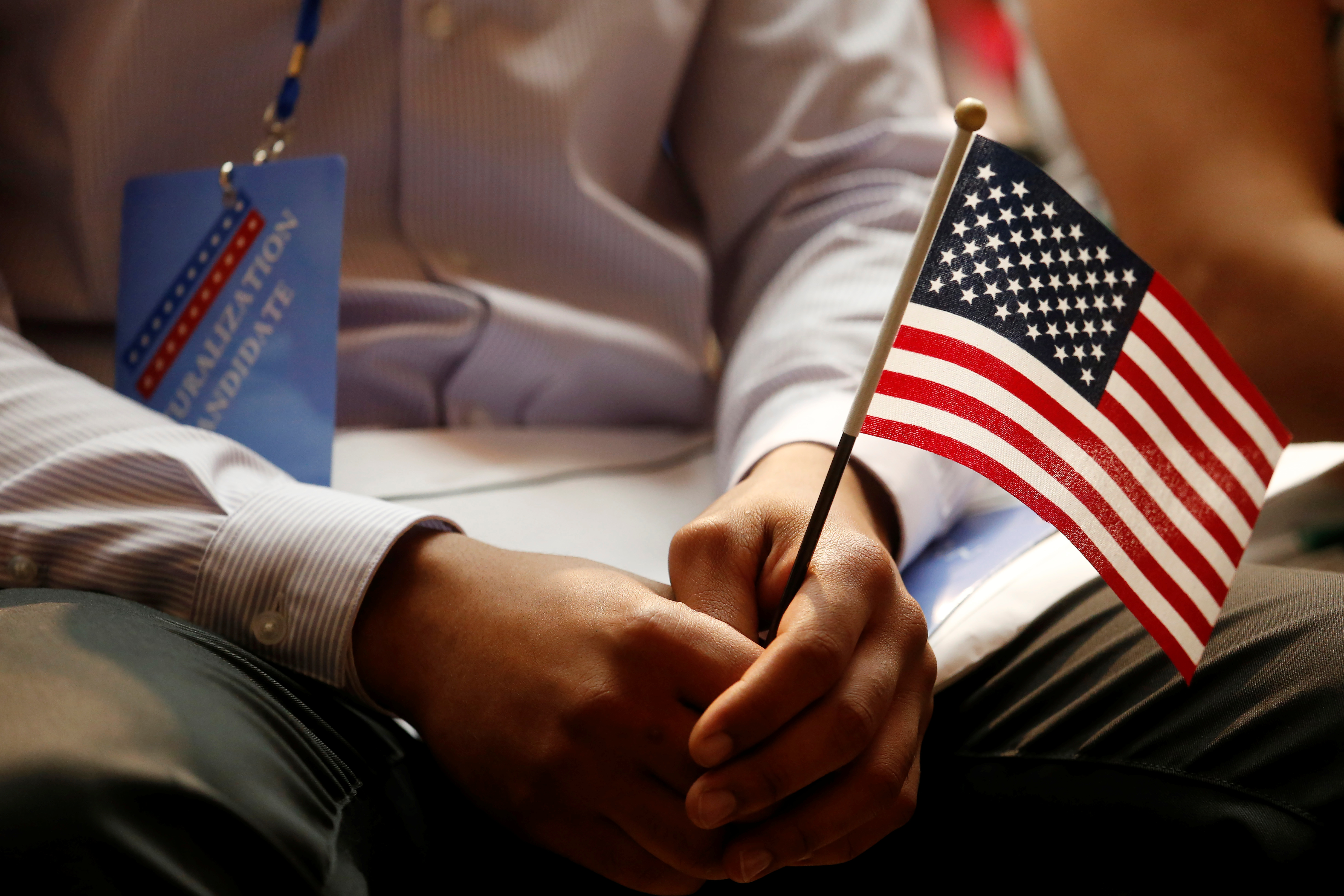 A new citizen holds a U.S. flag at the U.S. Citizenship and Immigration Services (USCIS) naturalization ceremony at the New York Public Library in Manhattan