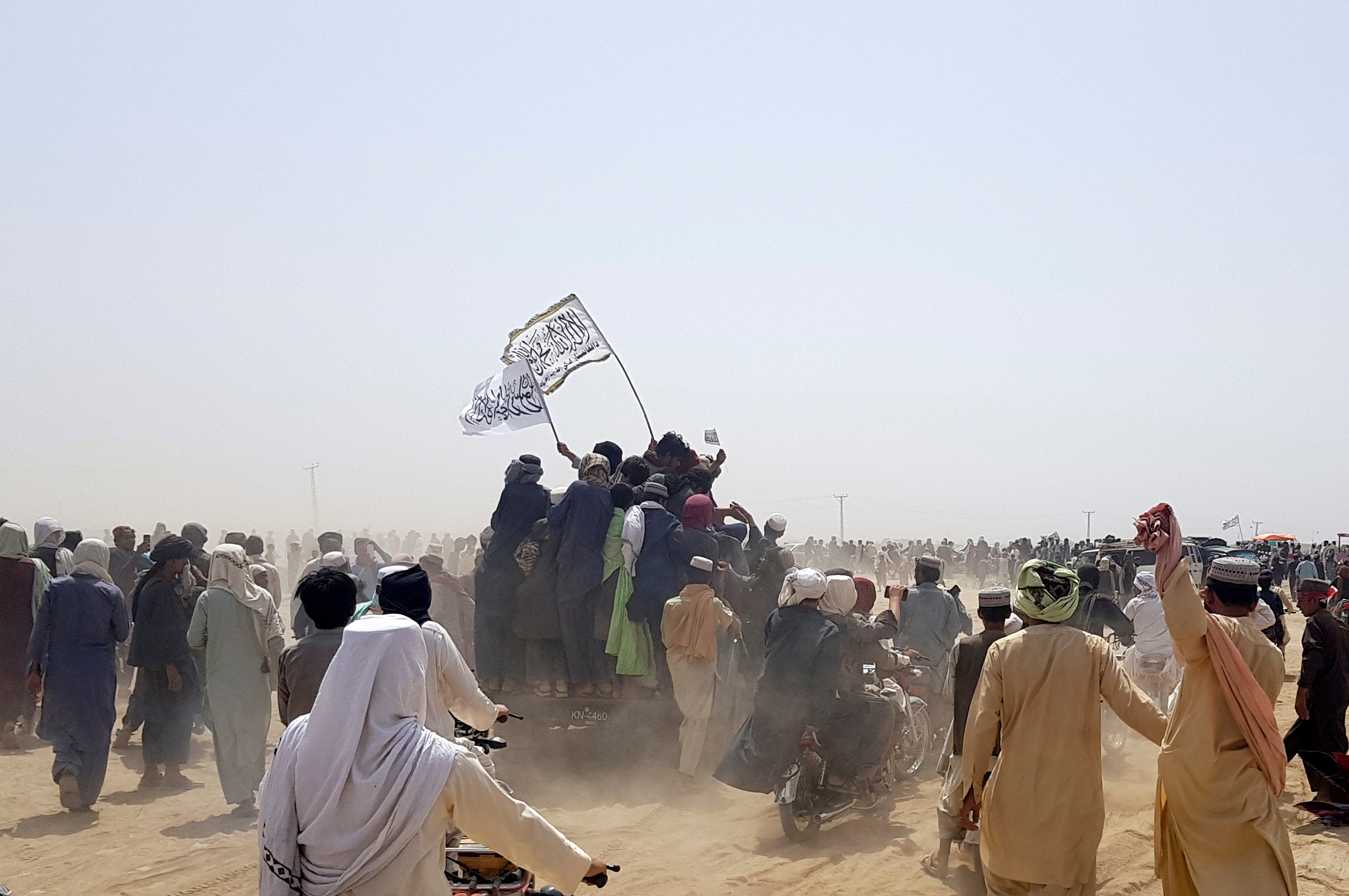 People on vehicles gather near Friendship Gate crossing on Pakistan-Afghanistan border, in Chaman