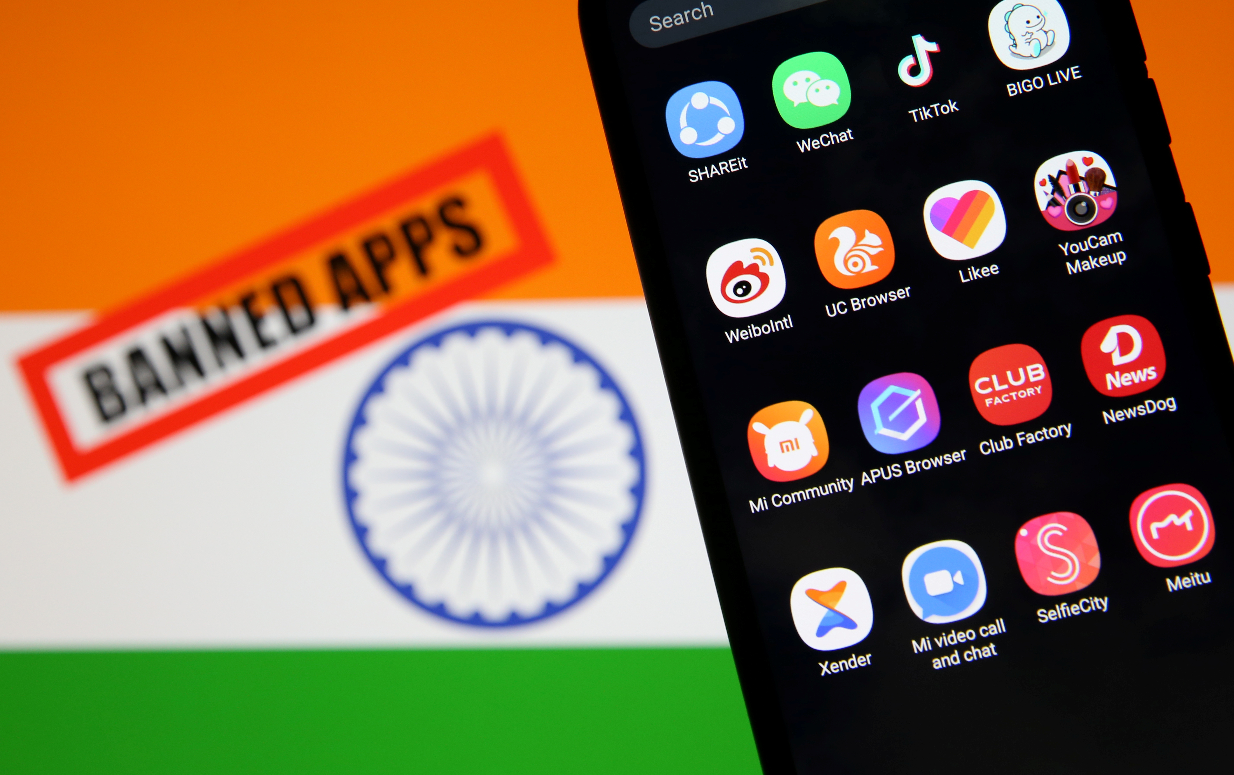 Smartphone with Chinese applications is seen in front of a displayed Indian flag and a 
