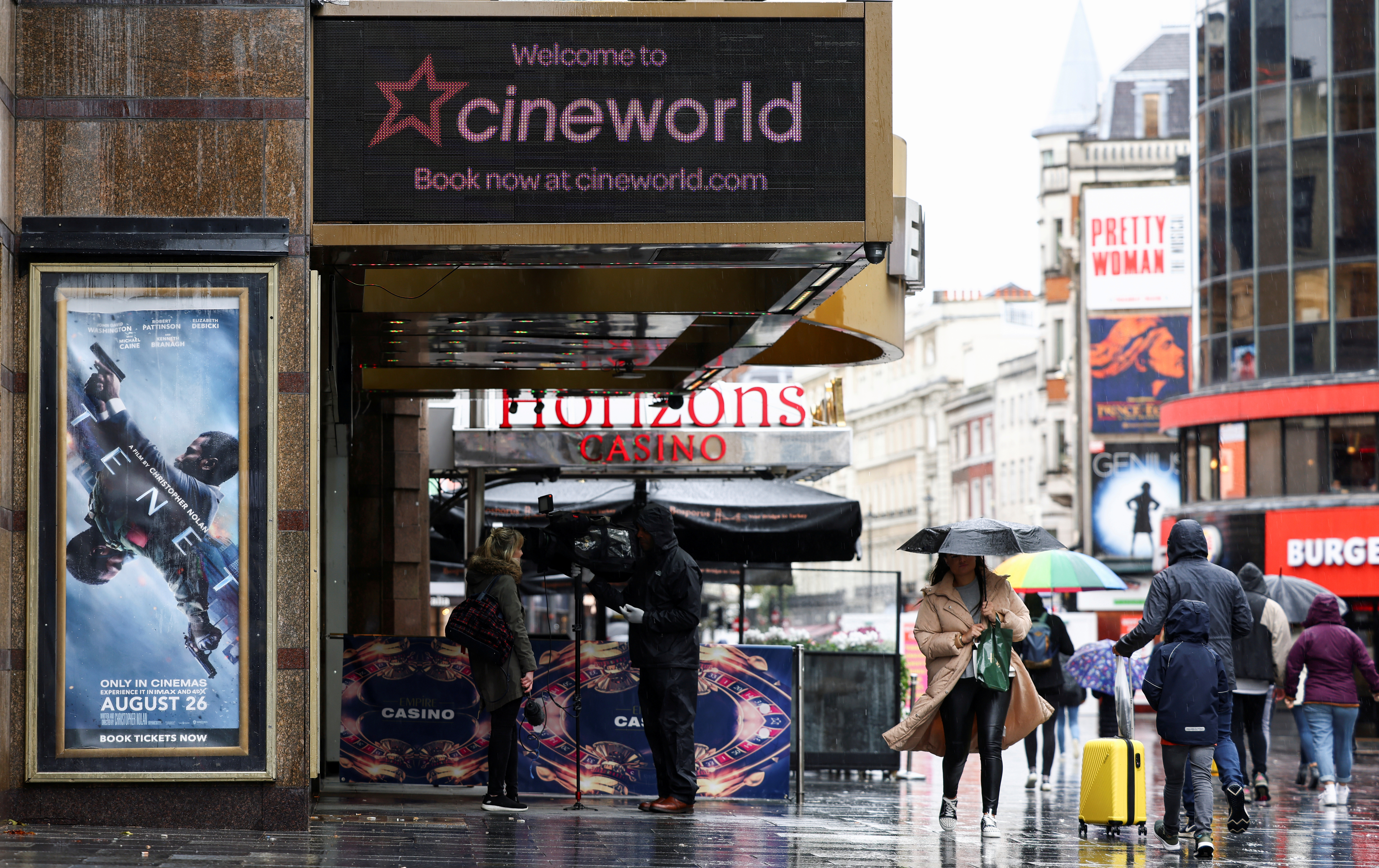 People walk past a Cineworld in Leicester's Square in London