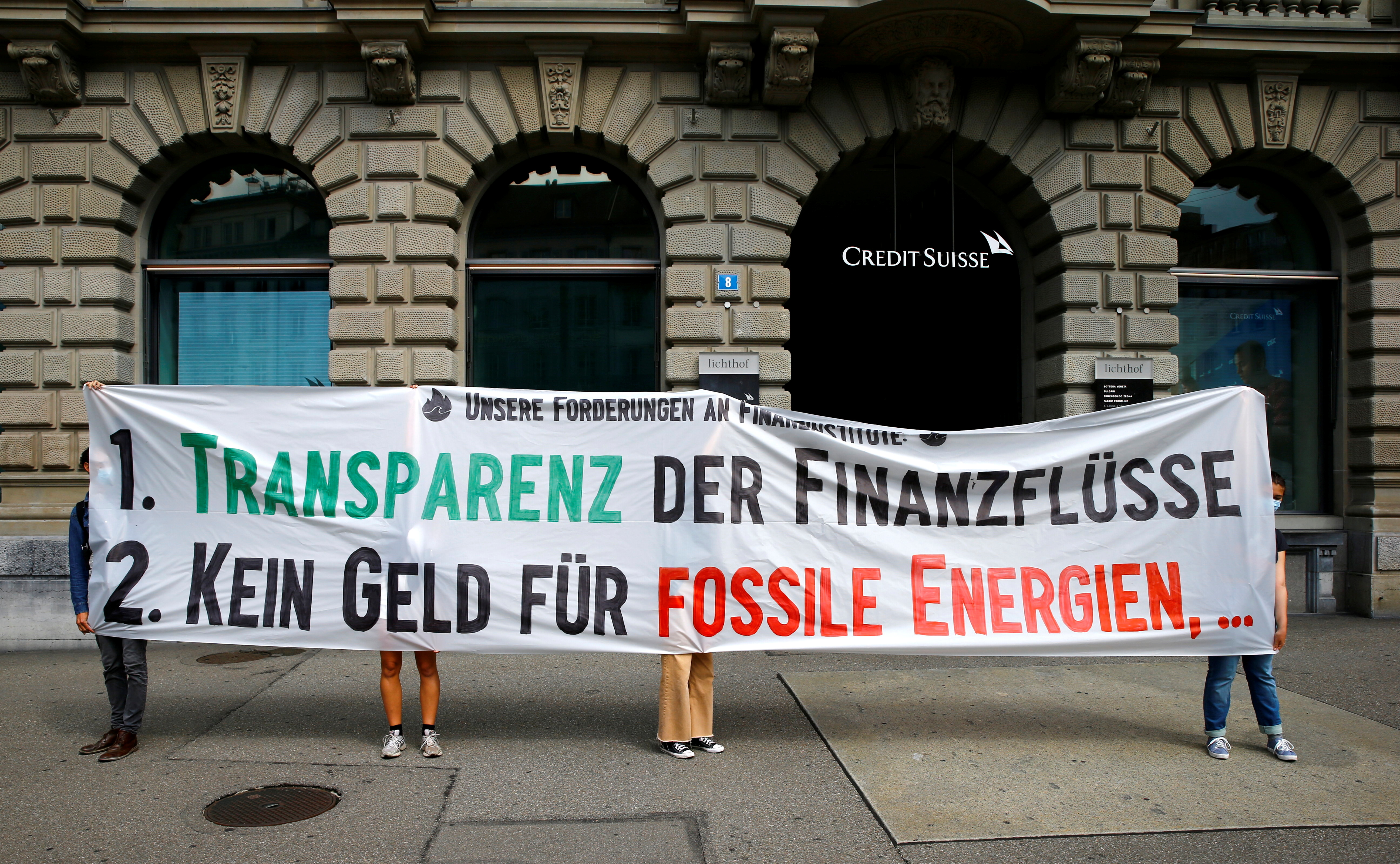 Climate activists of 'Rise up for Change' display a banner in front of the headquarters of Swiss bank Credit Suisse in Zurich