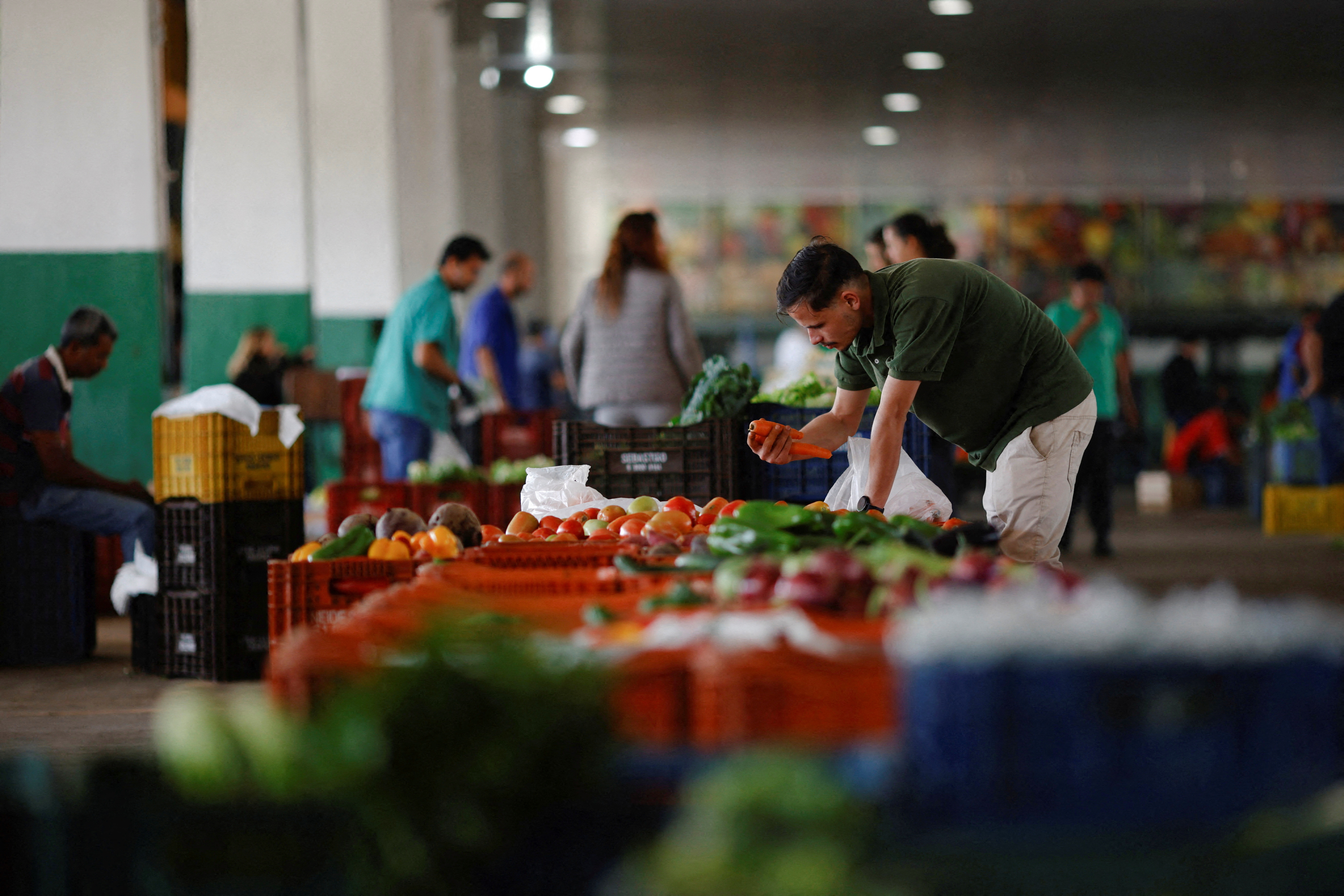 A salesman is seen at his vegetable stand at the supply centre (CEASA) in Brasilia