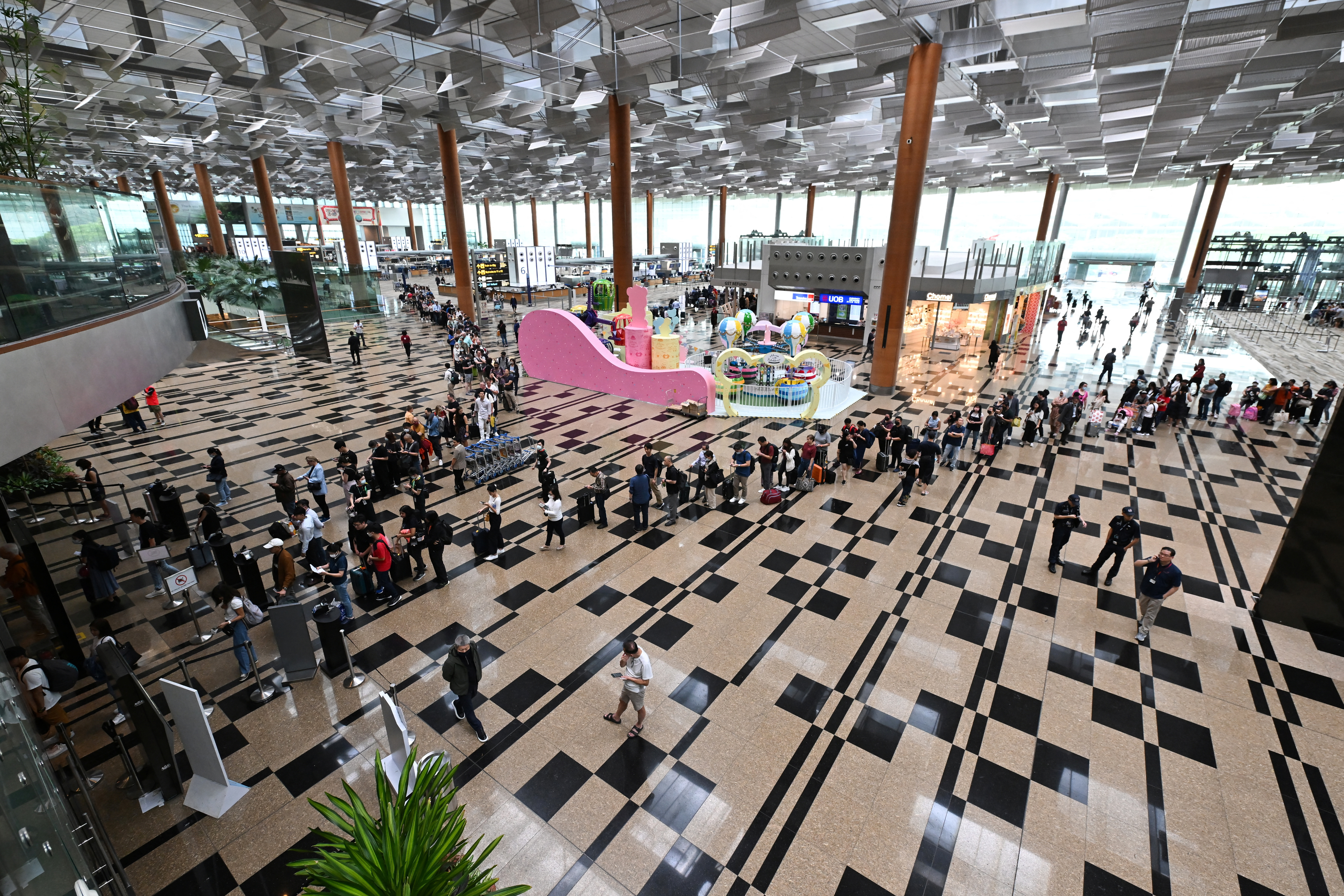 Passengers queue at the departure hall of Changi Airport Terminal 3 in Singapore