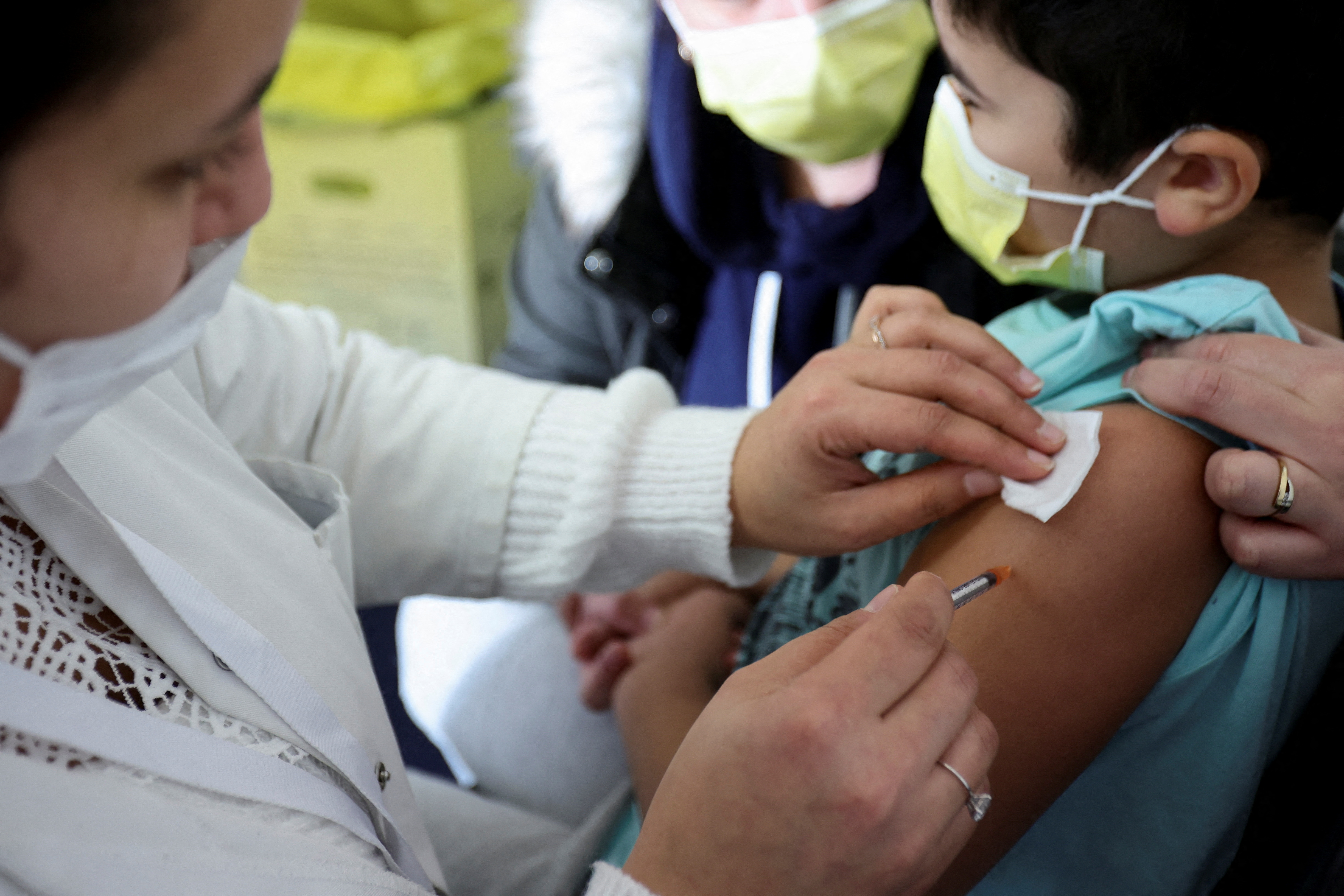 A medical worker administers a dose of a coronavirus disease (COVID-19) vaccine to a child at a vaccination centre in Les Pavillons-sous-Bois, near Paris, France, December 18, 2021. REUTERS/Sarah Meyssonnier