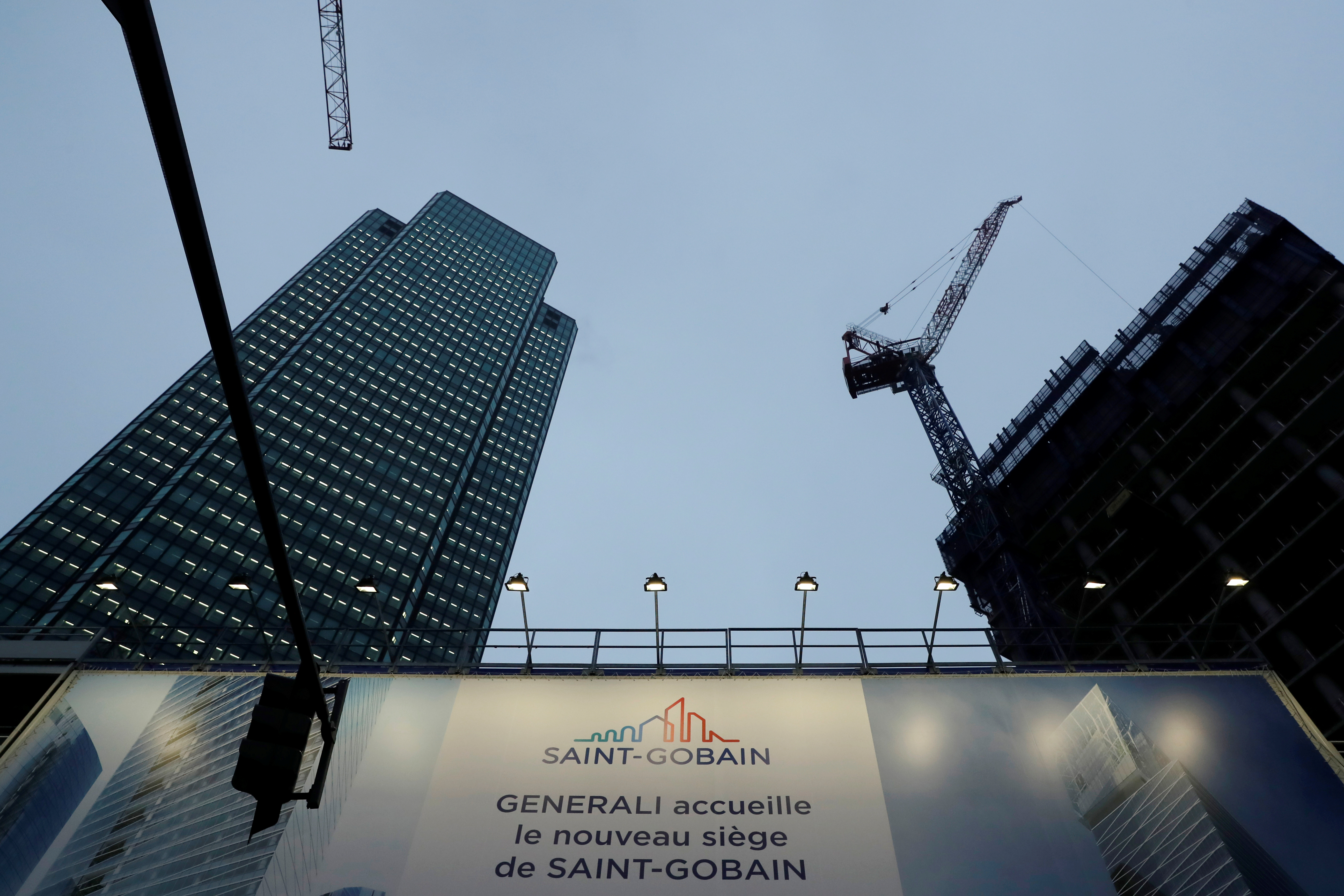 The logo of  Saint-Gobain is seen on a banner on a building construction site in the financial and business district of La Defense, outside Paris