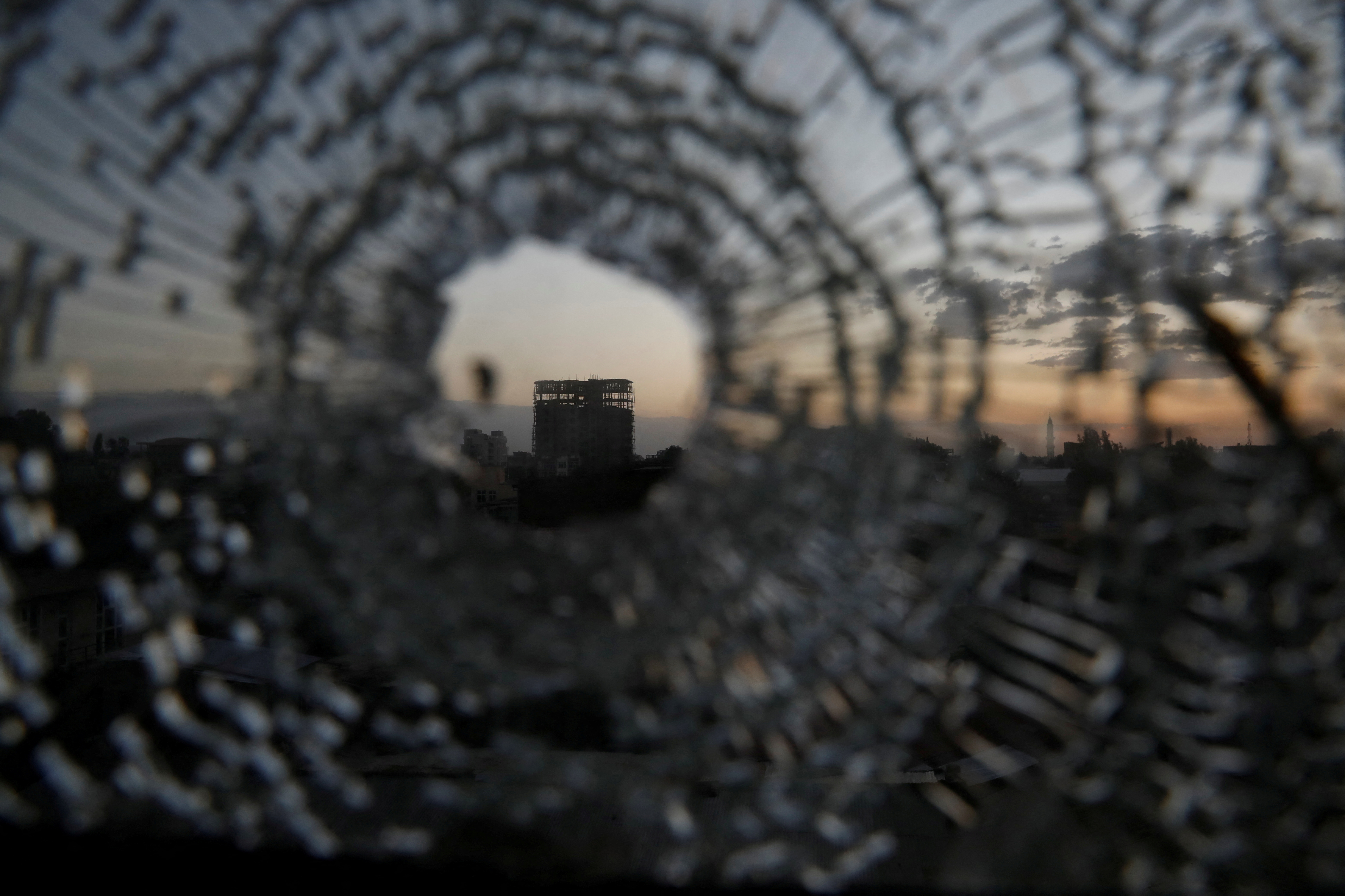 شوهد المبنى من خلال ثقب رصاصة في نافذة فندق أفريقيا في بلدة شاير ، منطقة تيغراي