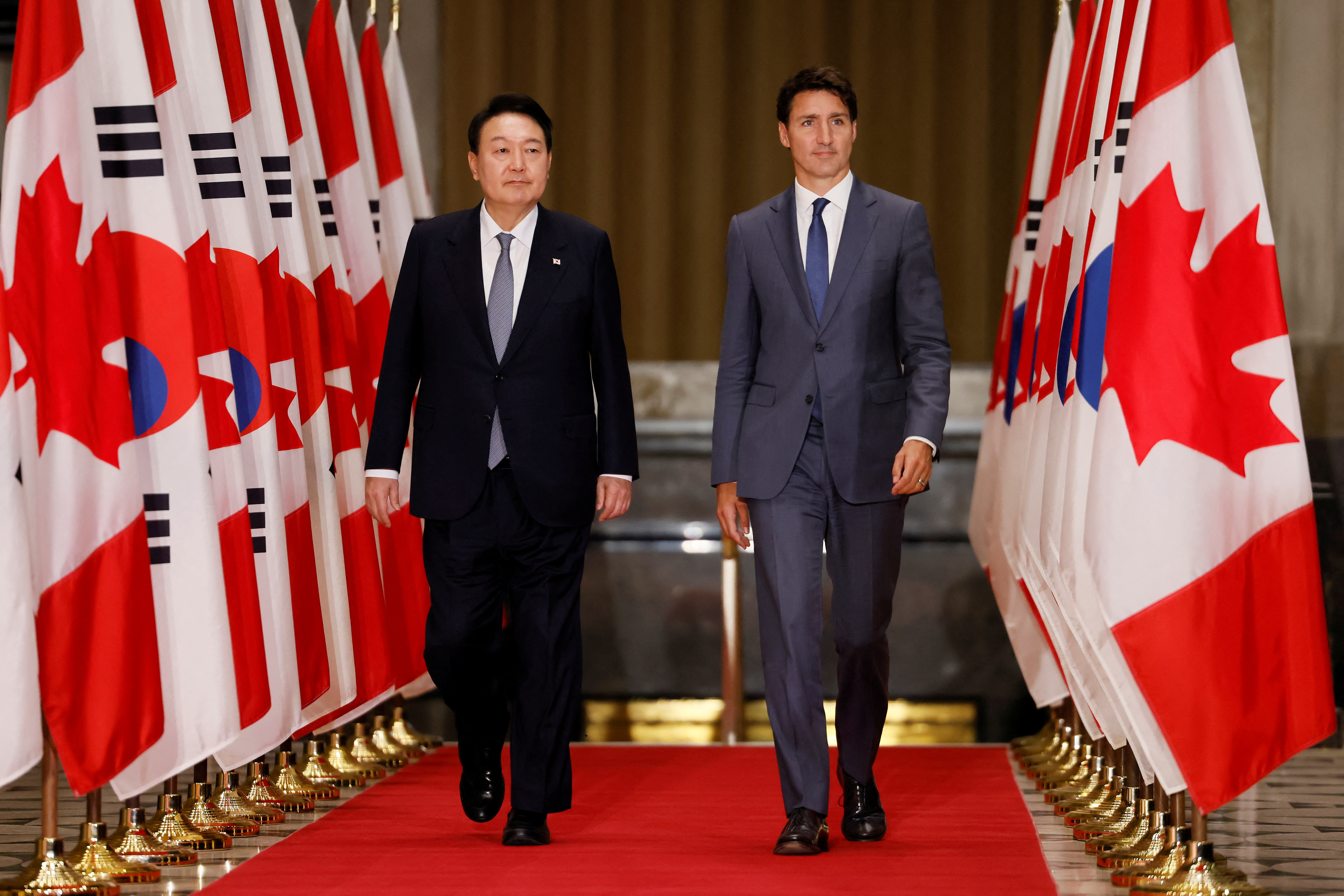 South Korean President Yoon Suk-yeol and Canada's Prime Minister Justin Trudeau arrive to a news conference in Ottawa