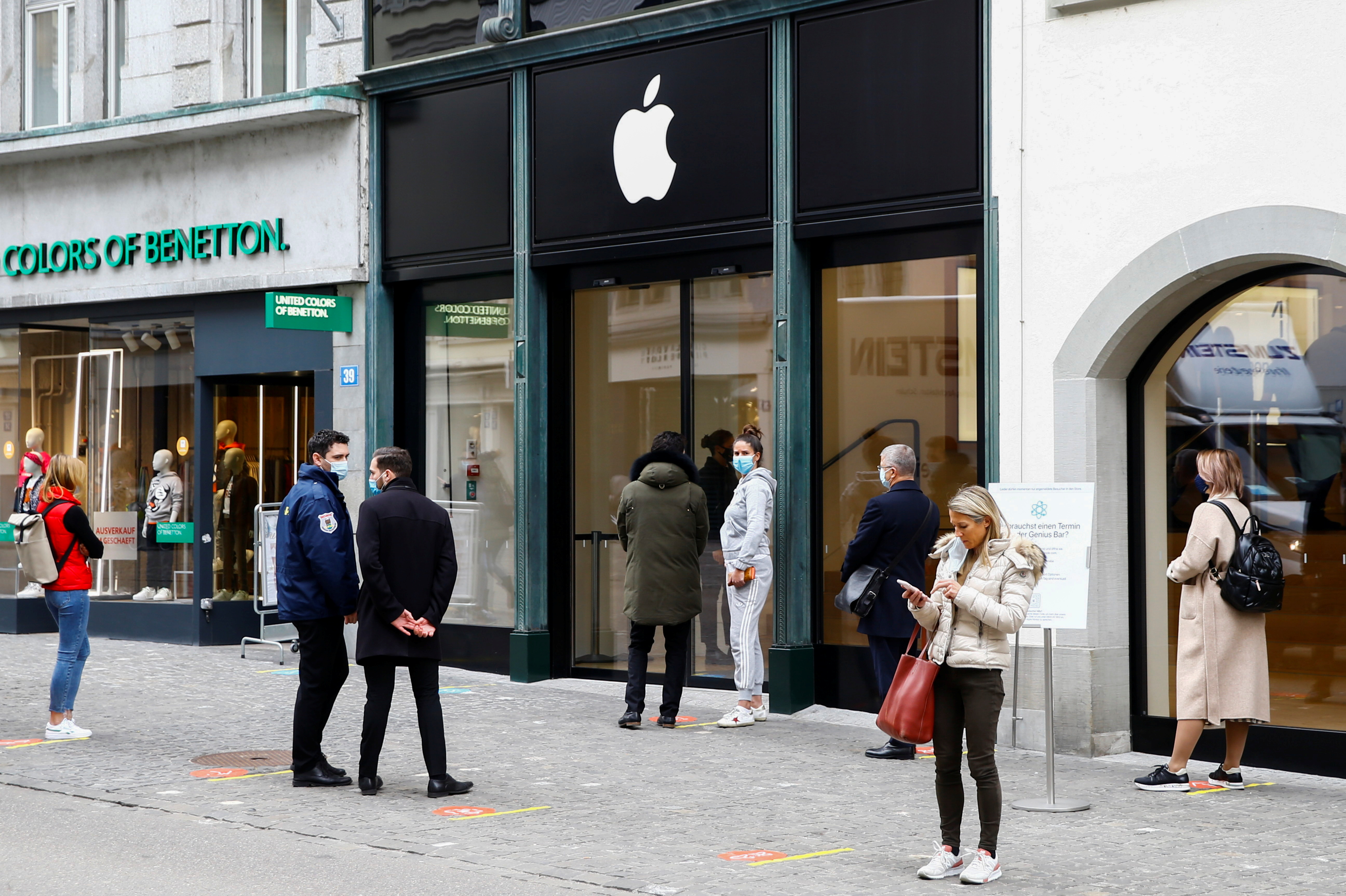 Clients wait in front of a re-opened Apple store after the Swiss government relaxed some of its COVID-19 restrictions in Zurich