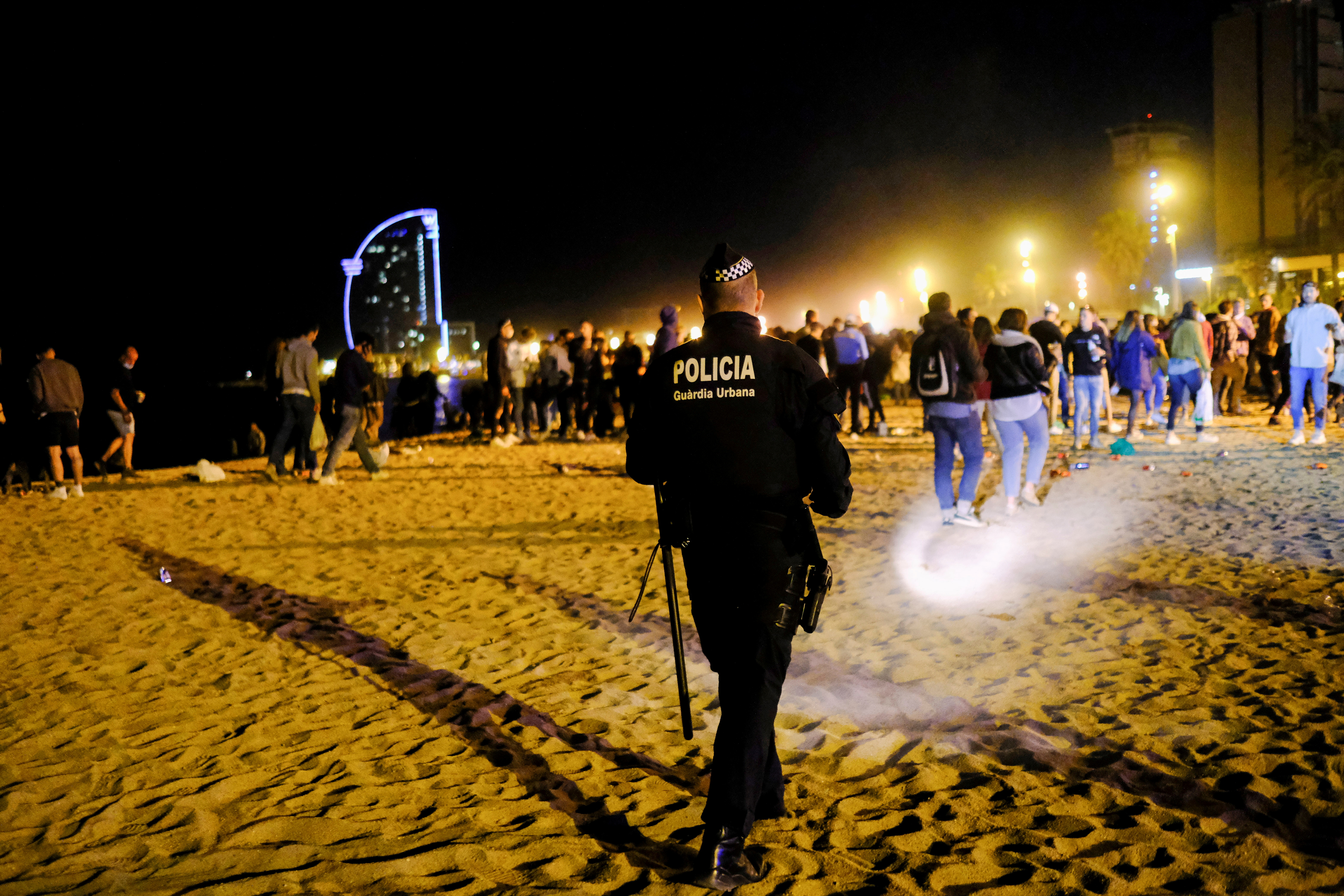 Poliser vräker grupper om mer än sex personer vid stranden Barceloneta, eftersom undantagstillståndet som den spanska regeringen beslutat för att förhindra spridningen av coronaviruset (COVID-19) hävdes för en vecka sedan i Barcelona, ​​Spanien, den 16 maj 2021. REUTERS/Nacho Doce