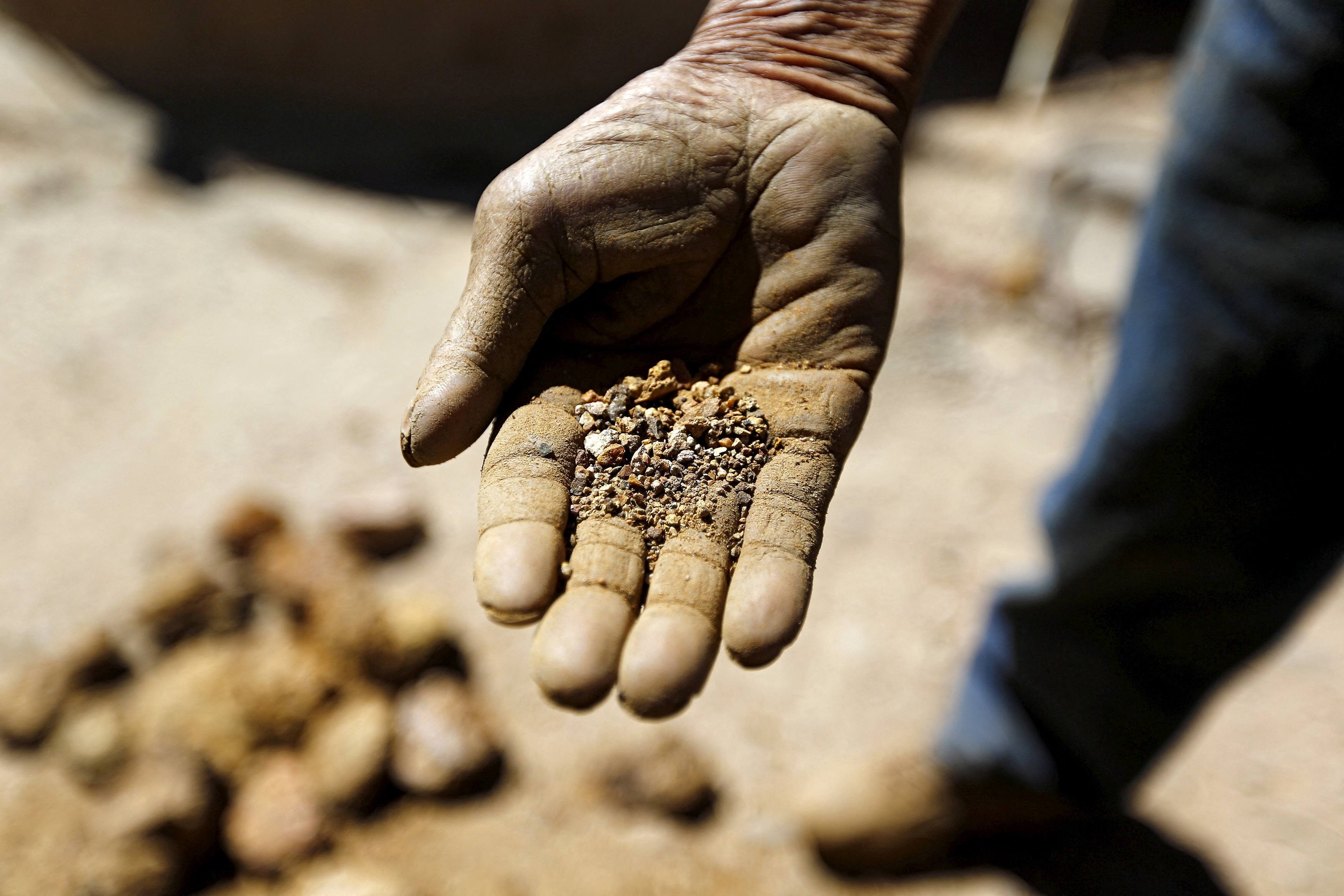An artisanal miner shows ore at a small copper and gold processing plant of the 