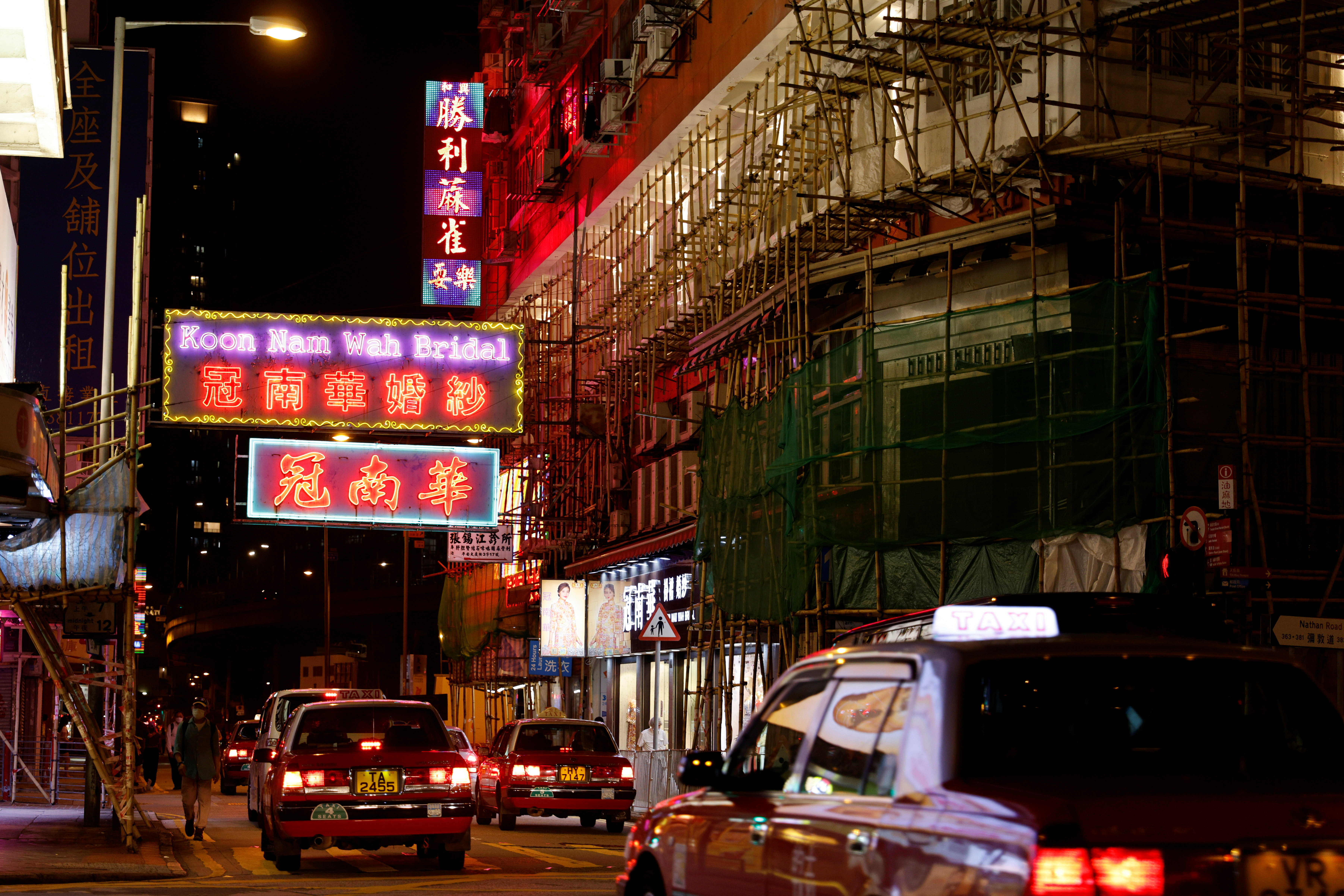 Taxis drive under neon and LED signs at Yau Ma Tei, in Hong Kong