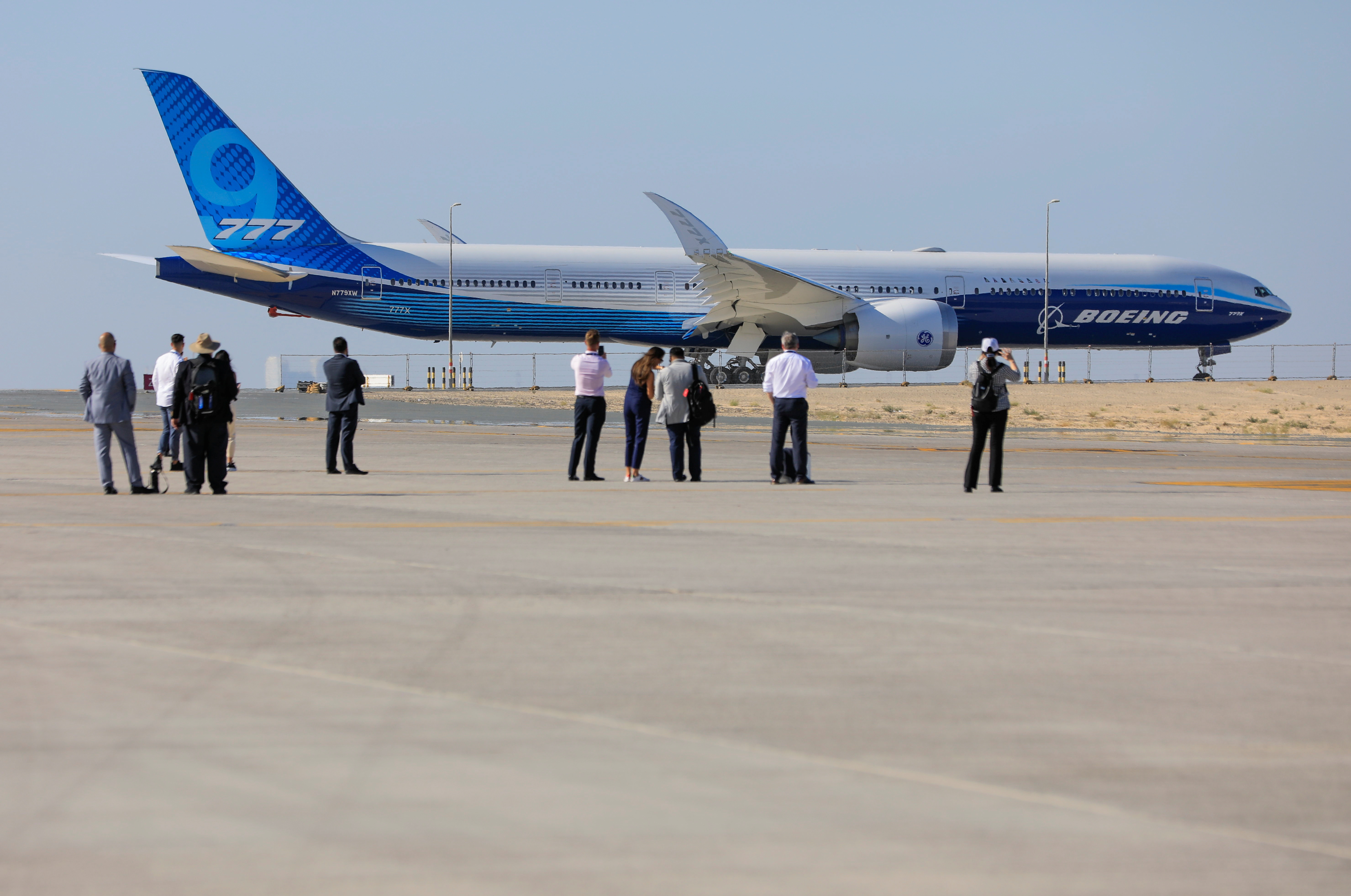 Visitors stand in front of the plane Boeing 777X during the Dubai Airshow, in Dubai