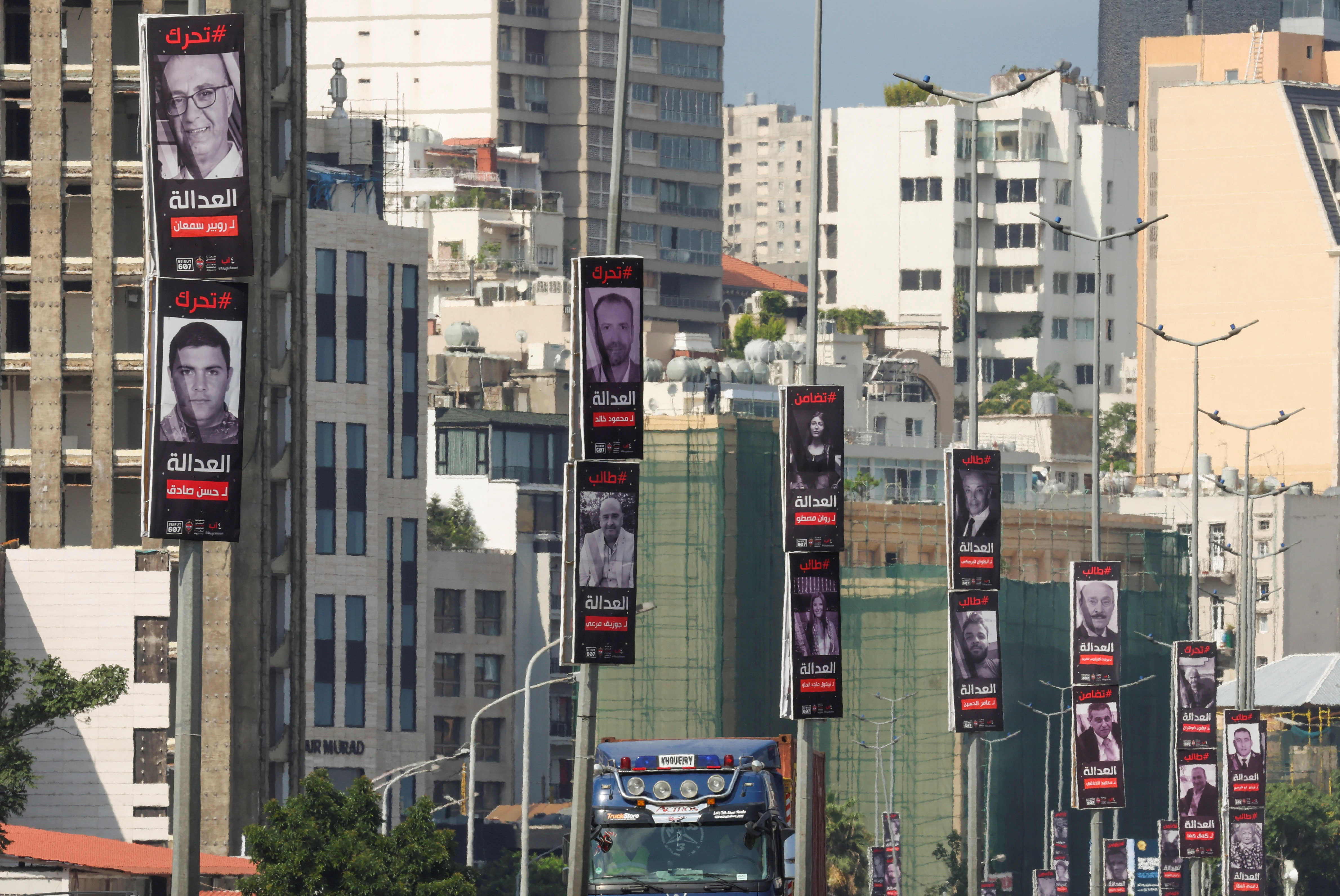 Posters of victims of the August 2020 Beirut port explosion hang on street poles along a highway in Beirut