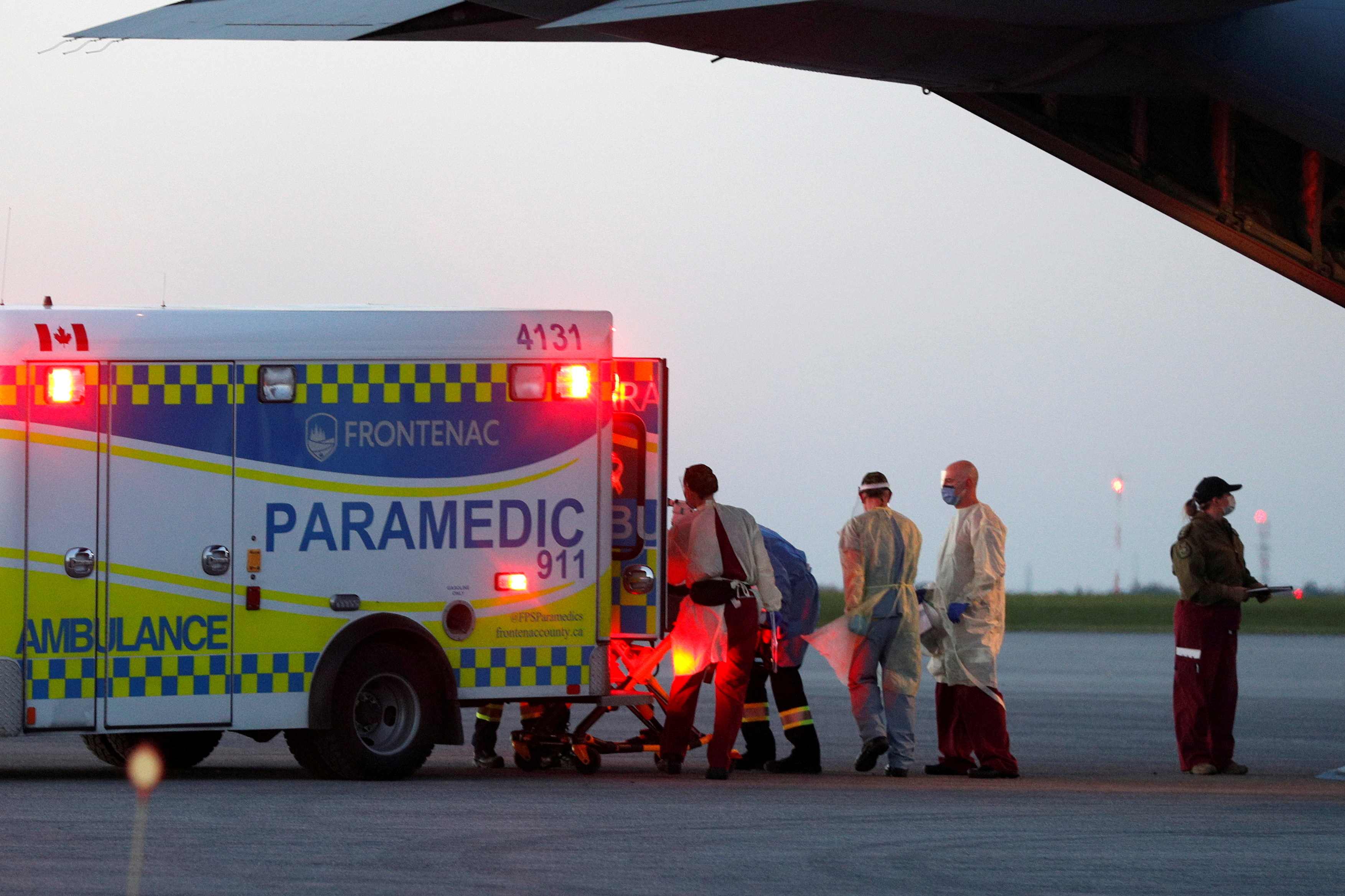 Medical personnel unload a patient from a Royal Canadian Air Force CC-130J aircraft in Kingston