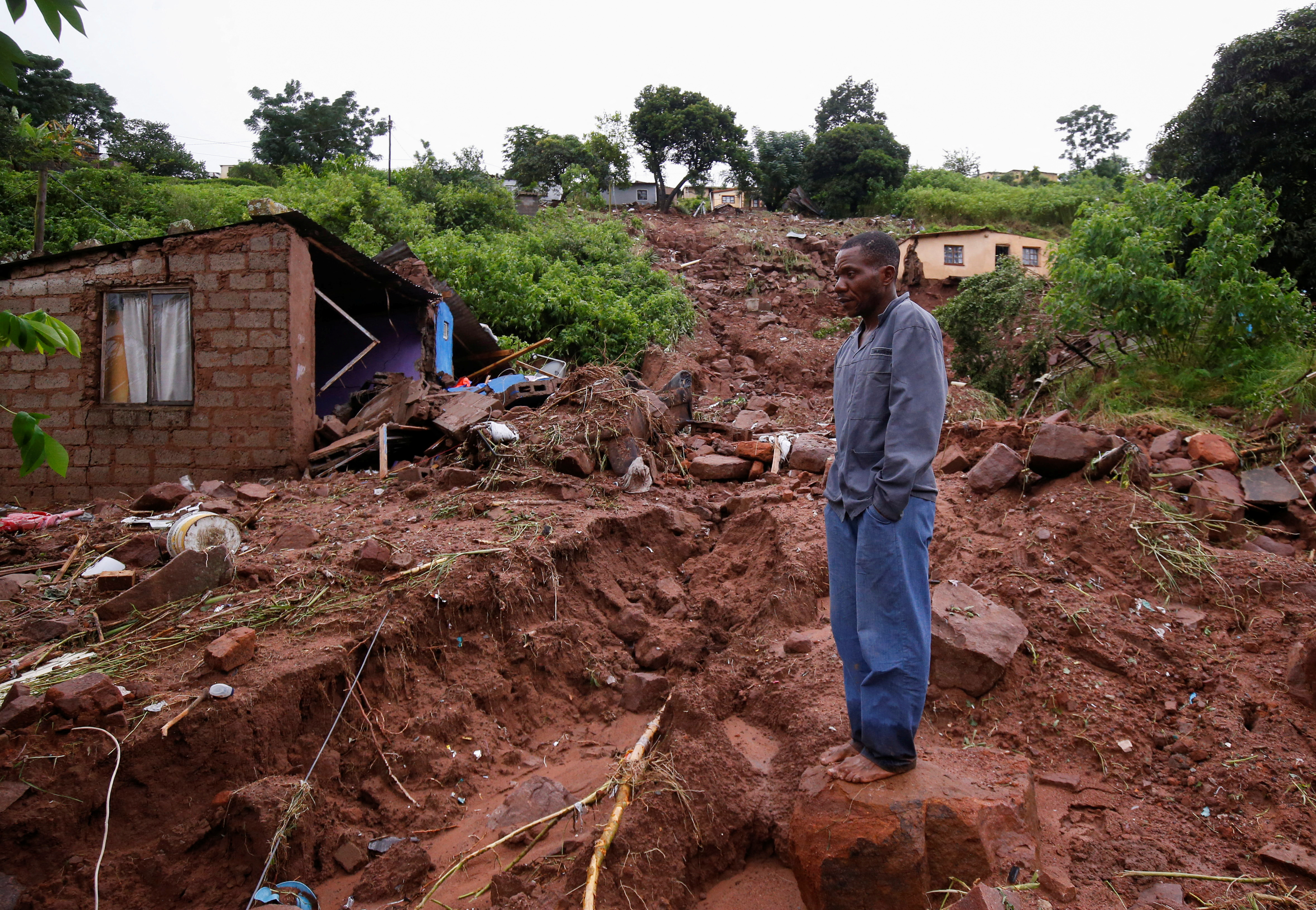 Jomba Phiri walks over where his house stood after heavy rains caused flood damage in KwaNdengezi, Durban