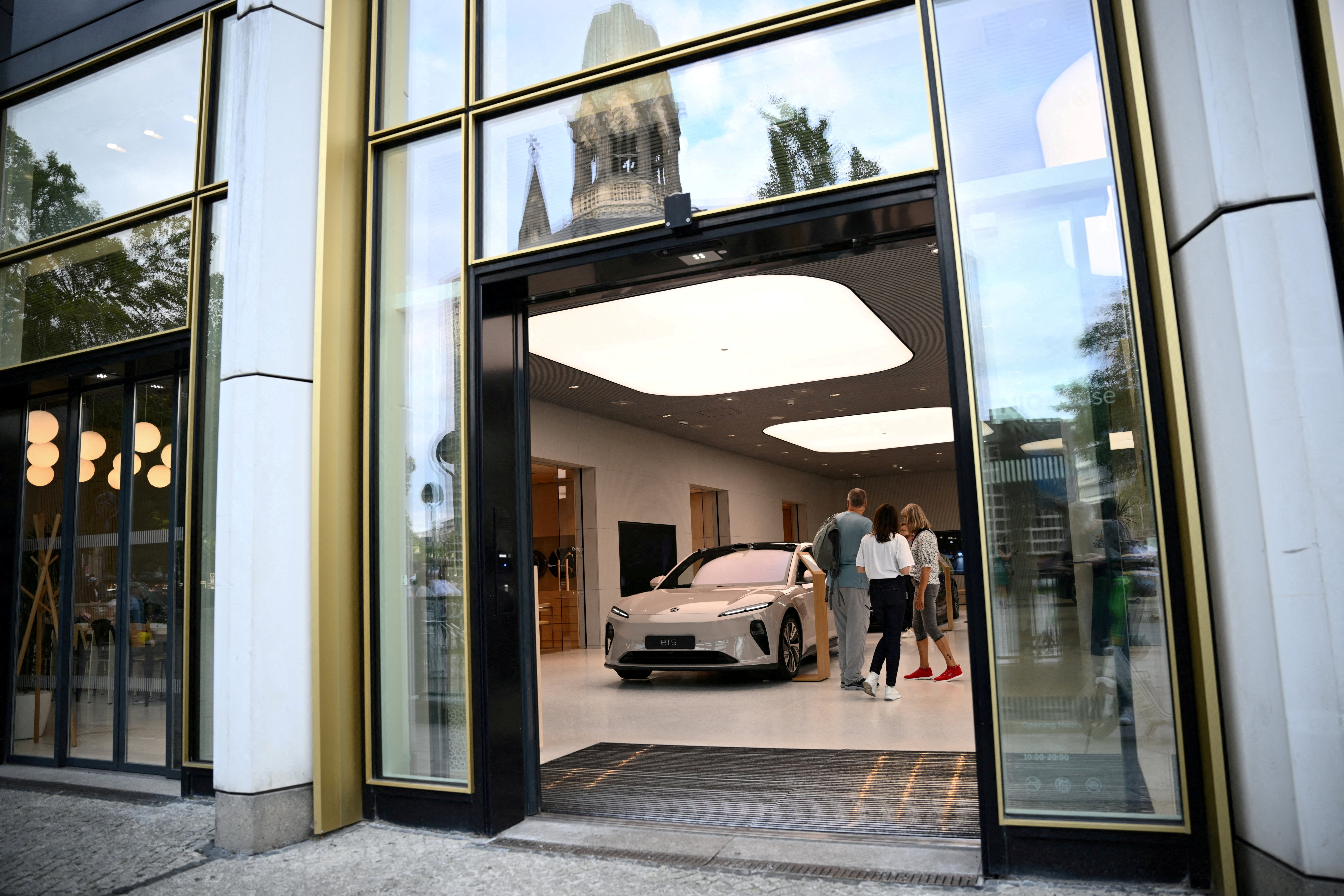 FILE PHOTO: People stand near NIO ET5 car model at the NIO House, the showroom of the Chinese premium smart electric vehicle manufacture NIO Inc. in Berlin