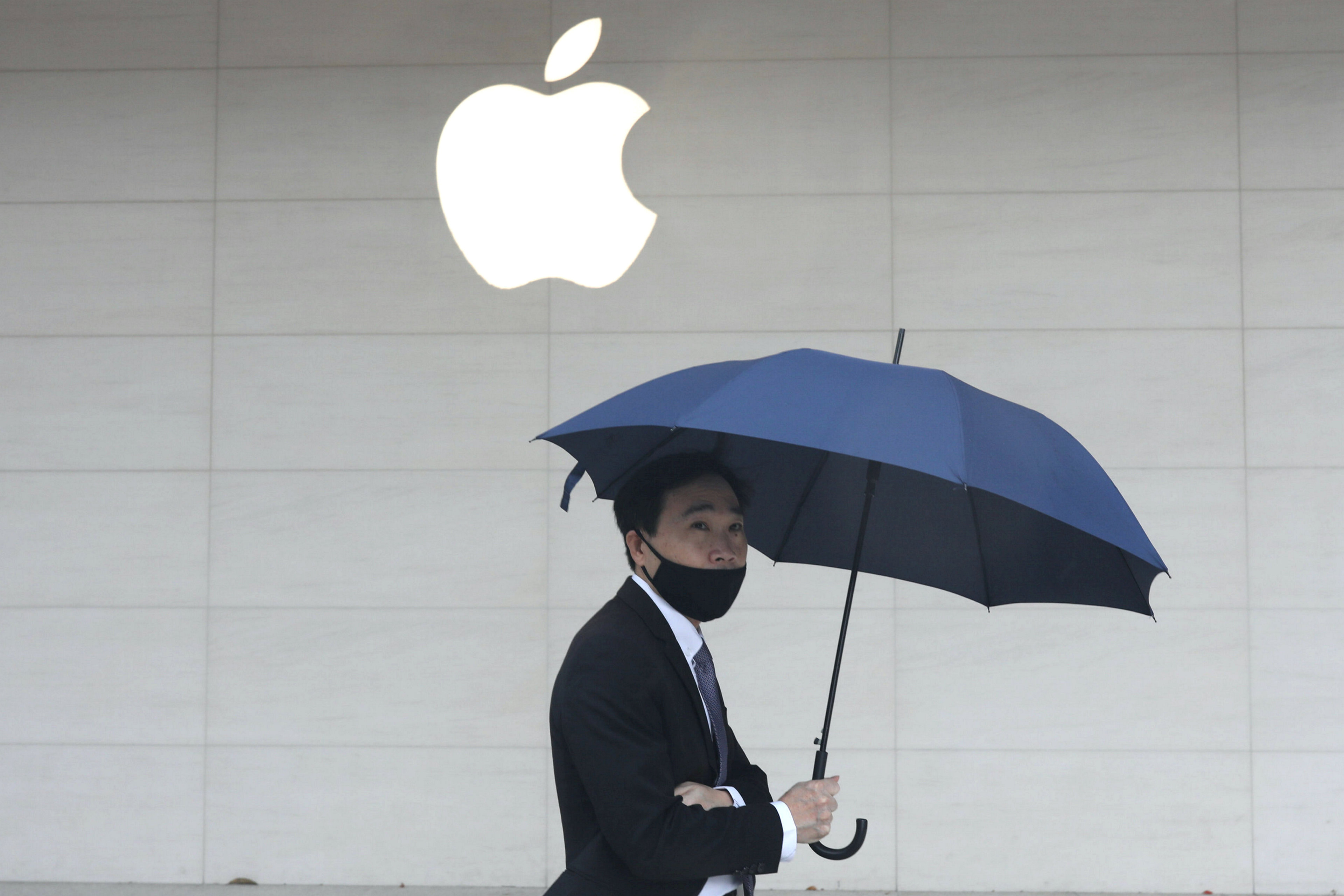 Man walks past an Apple store in Taipei