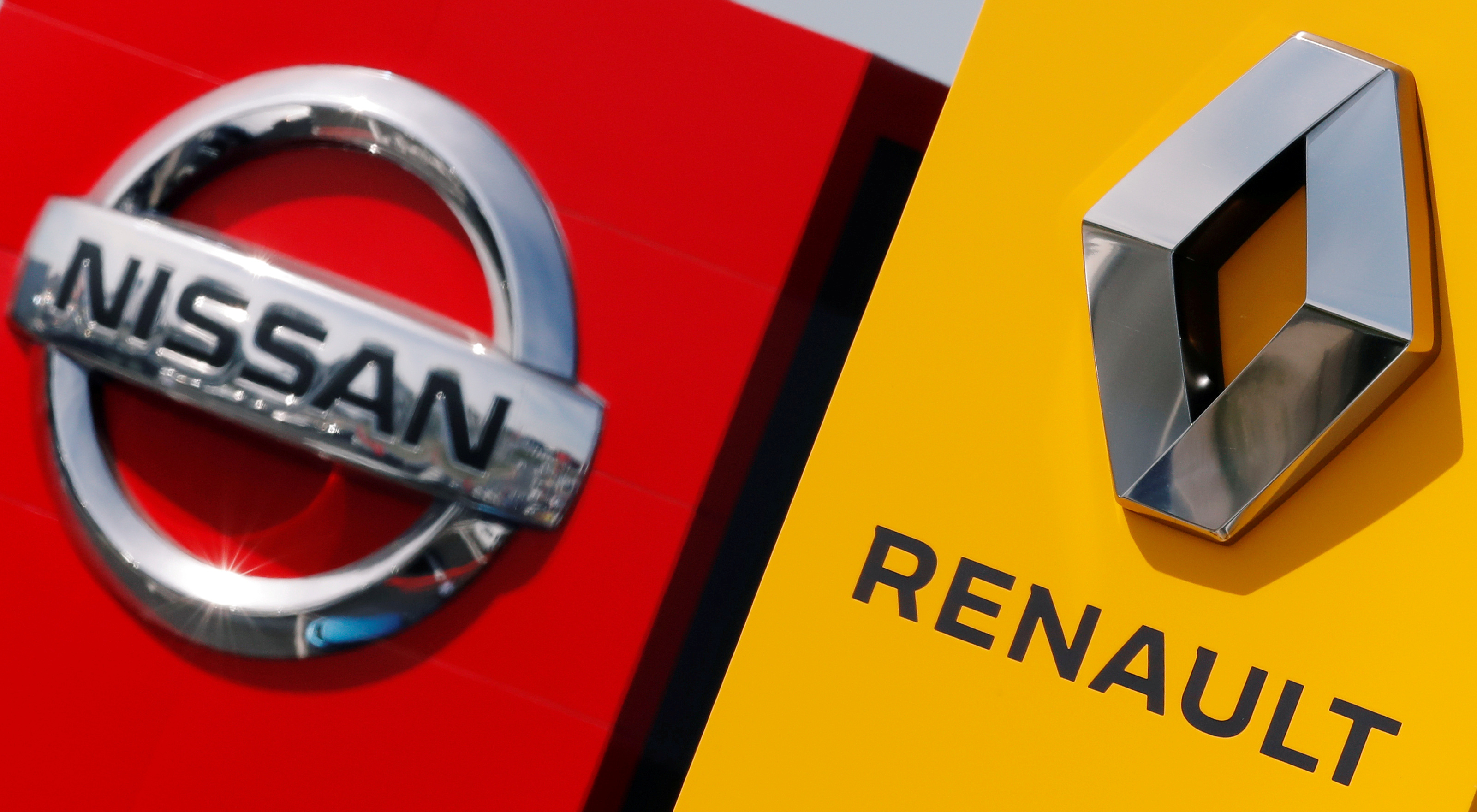 The logos of car manufacturers Renault and Nissan are seen in front of dealerships of the companies in Reims