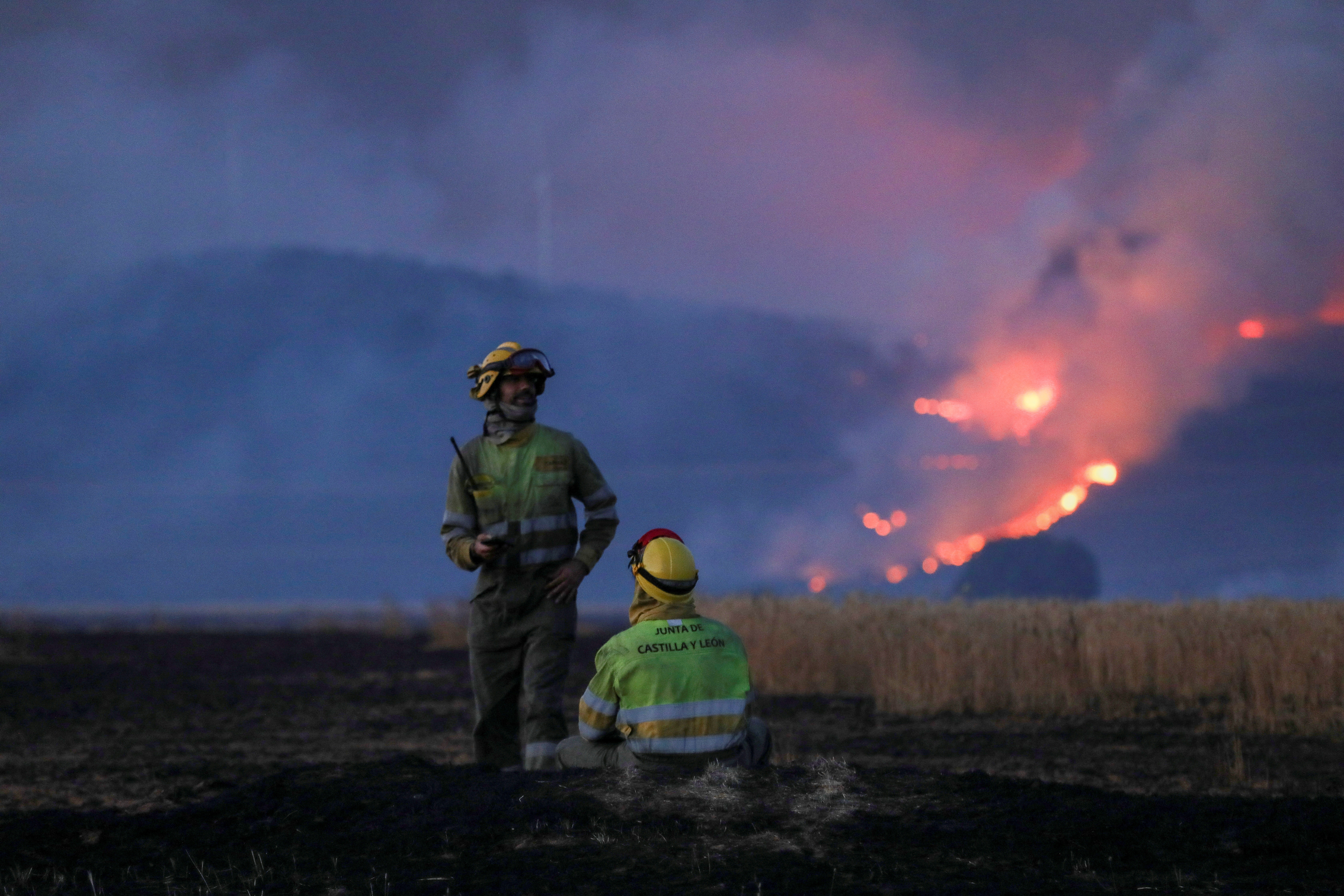 Firefighters work at the site of a wildfire outside Tabara, Zamora, on the second heatwave of the year