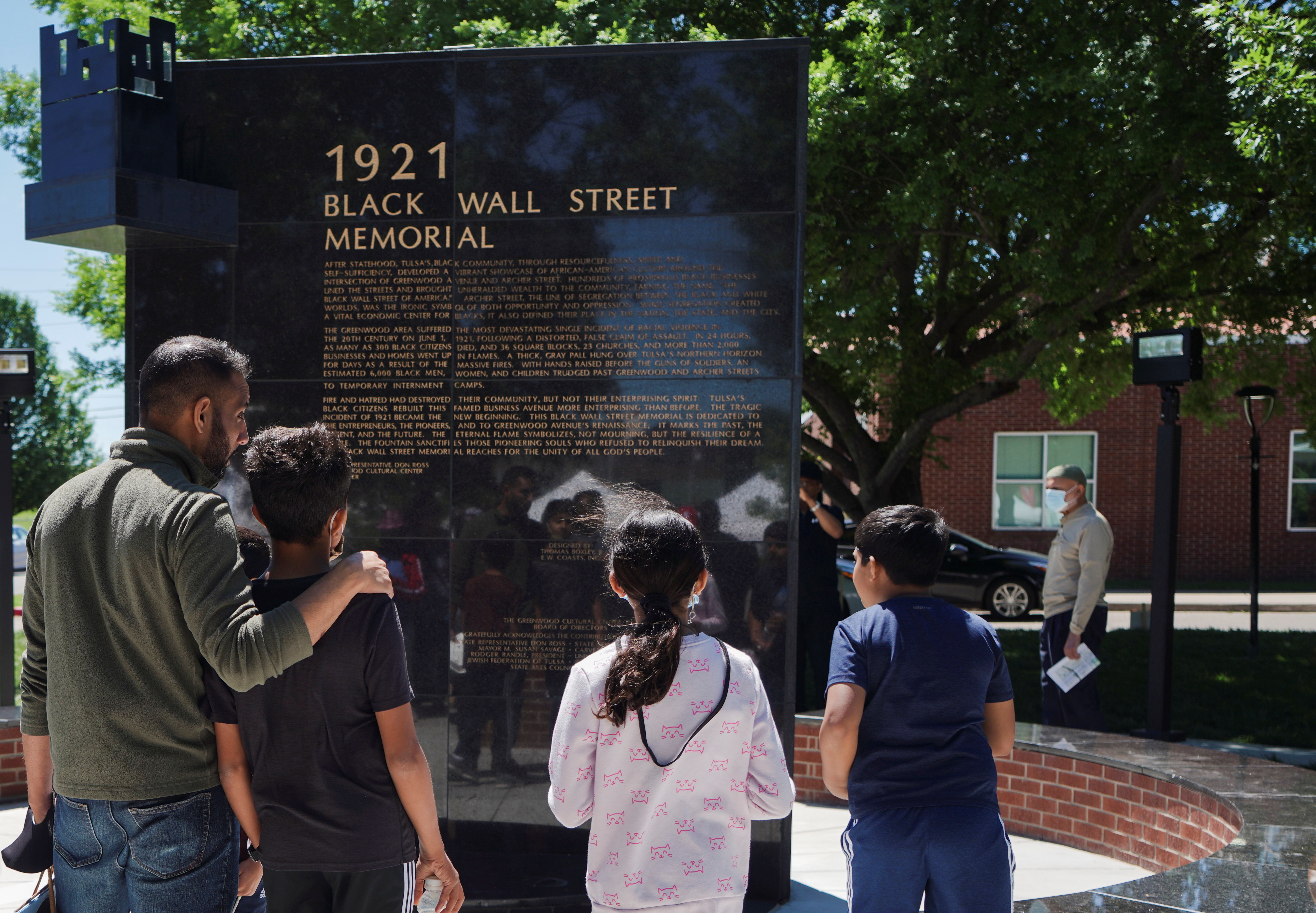 A family reads the Black Wall Street Memorial during festivities of the 100 year anniversary of the 1921 Tulsa Massacre in Tulsa