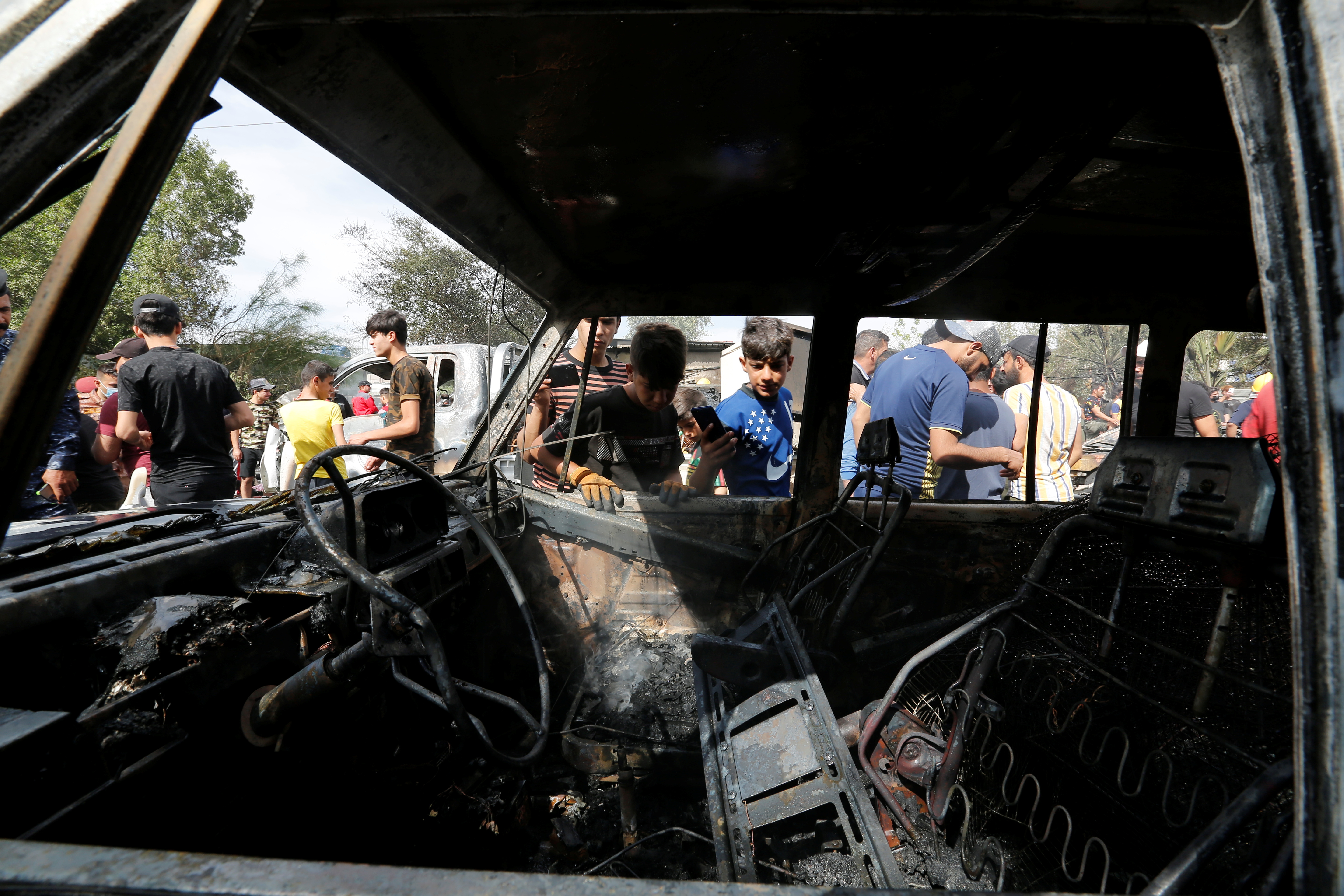 People inspect the site of a car bomb attack in Sadr City district of Baghdad