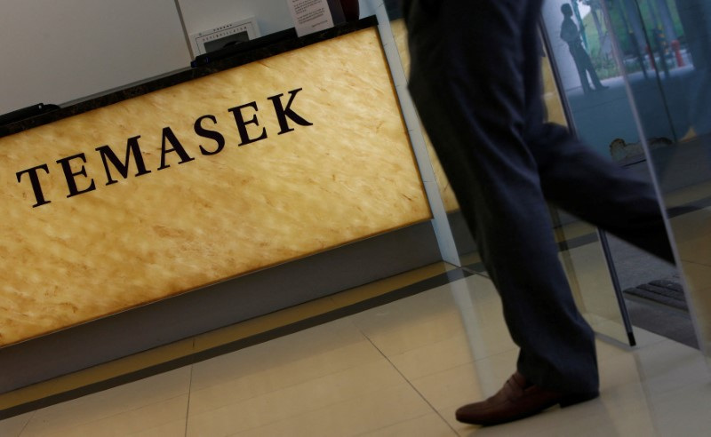 Man passes a logo of state investor Temasek Holdings at their office in Singapore