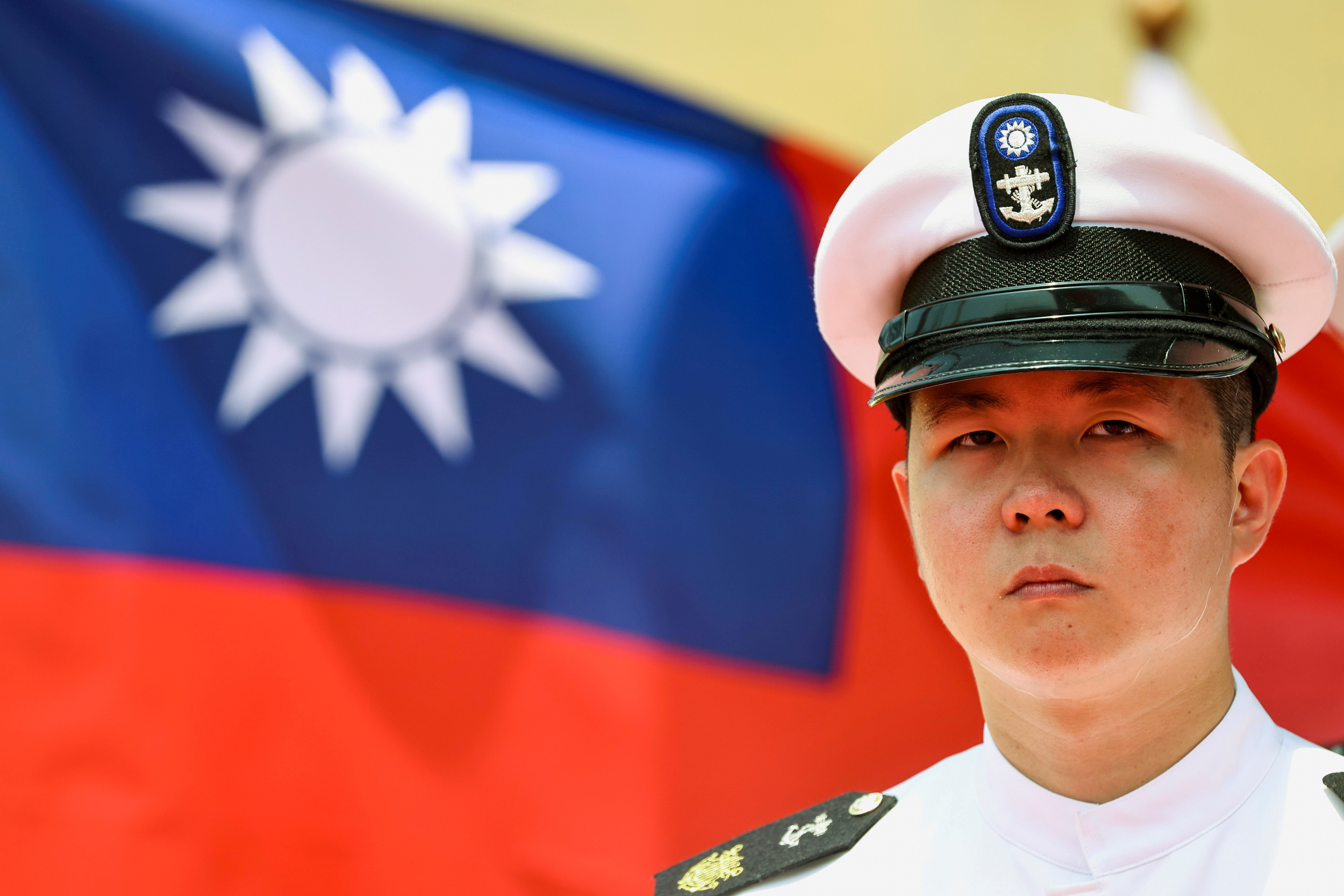 A Taiwan Navy honor guard looks on in front of a Taiwan flag during the  launch ceremony for Taiwan Navy's domestically built amphibious transport dock 