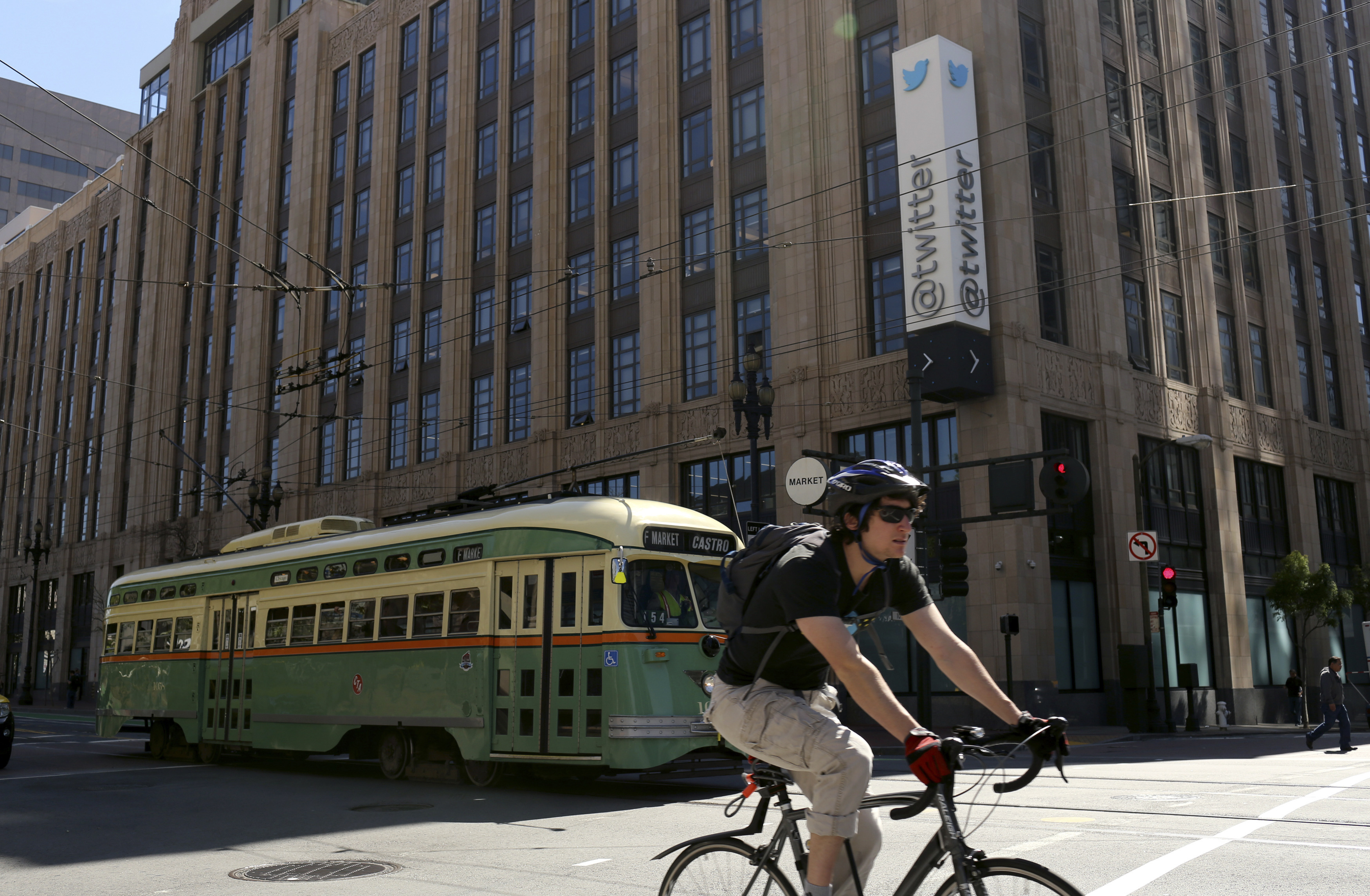 A vintage streetcar passes in front of the Twitter headquarters on Market Street in San Francisco