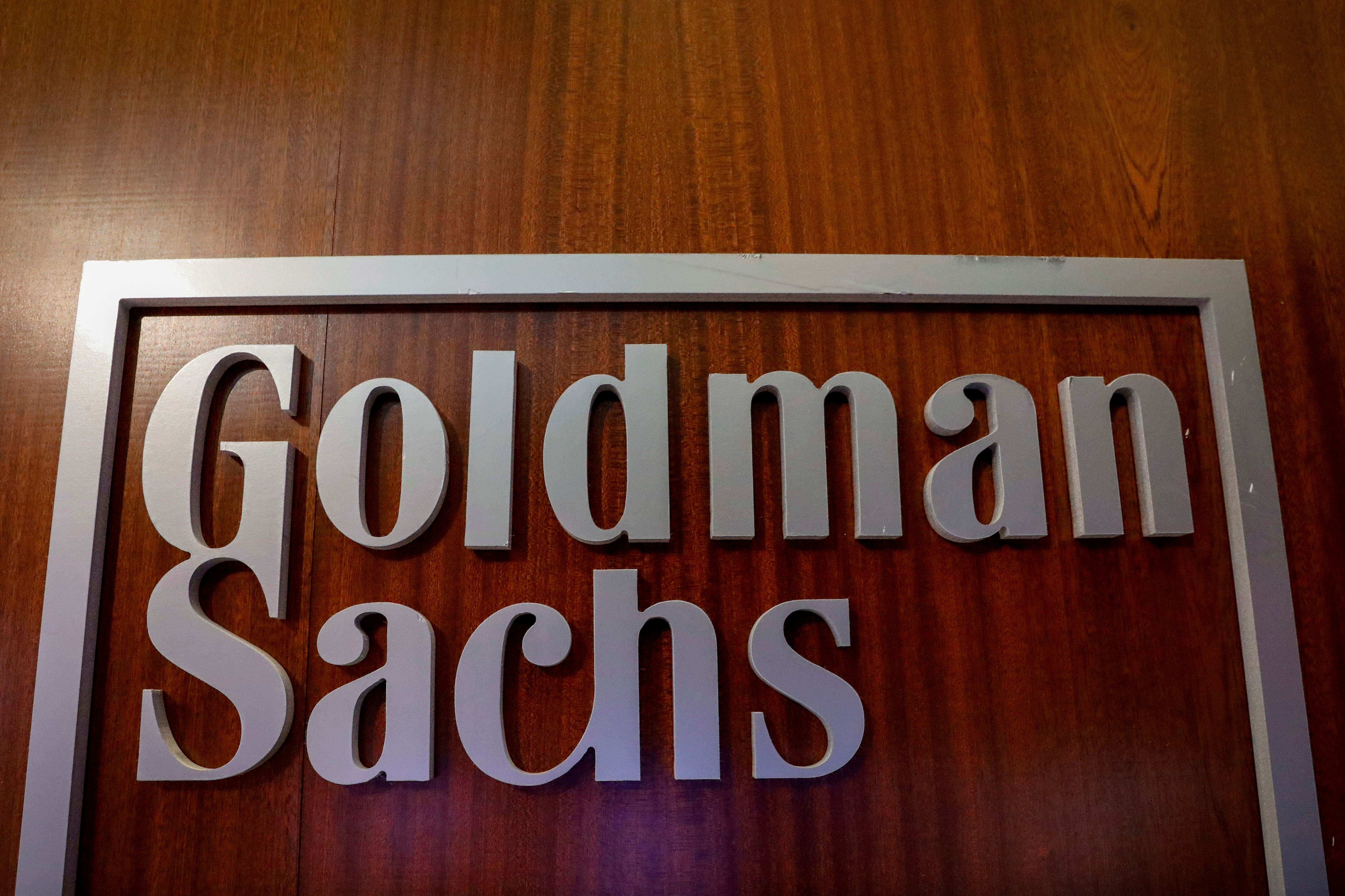 FILE PHOTO: FILE PHOTO: The Goldman Sachs company logo is seen in the company's space on the floor of the NYSE in New York
