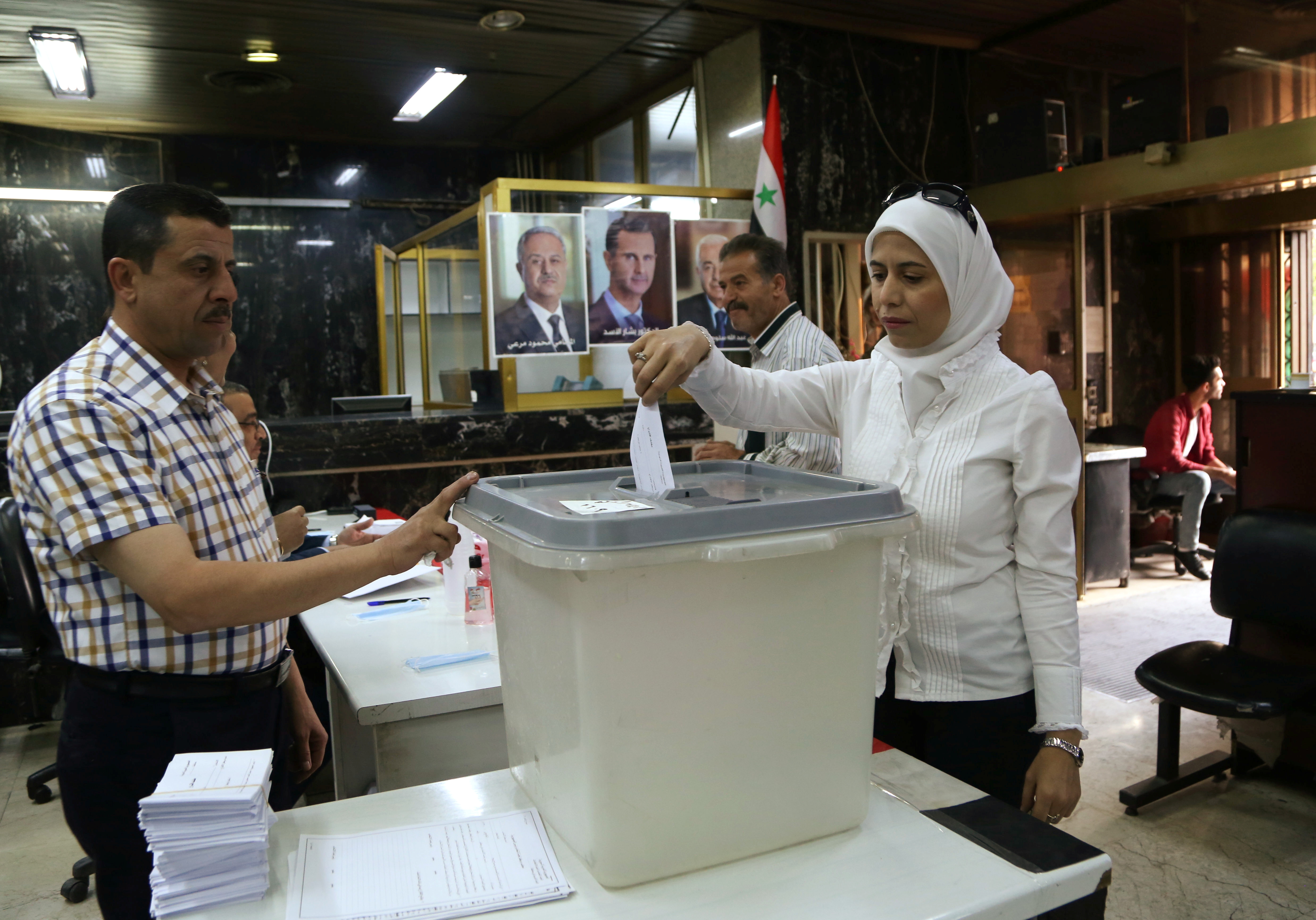 A woman casts her vote at a polling station during the presidential elections in Damascus