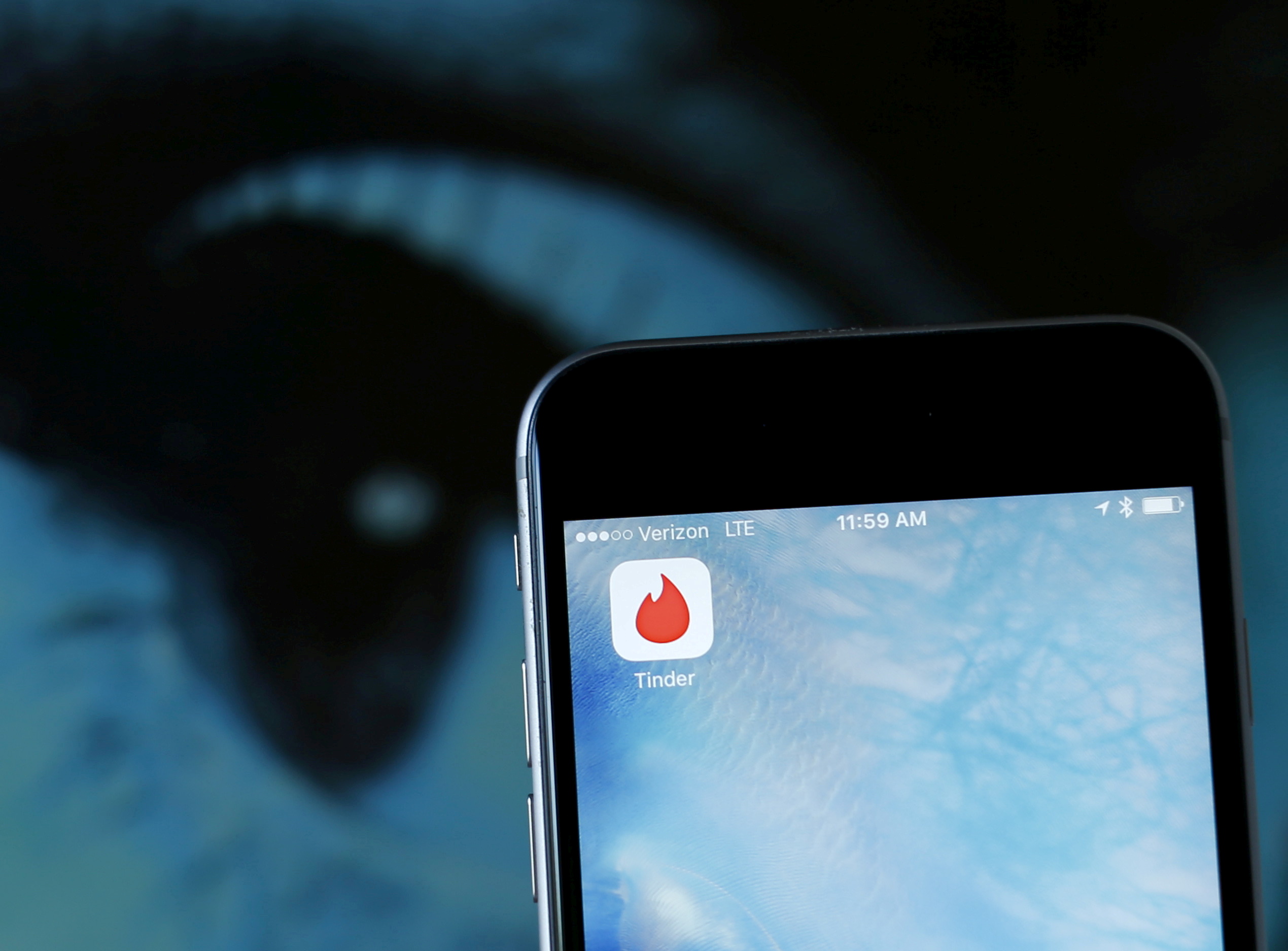 Photo illustration of dating app Tinder shown on an Apple iPhone