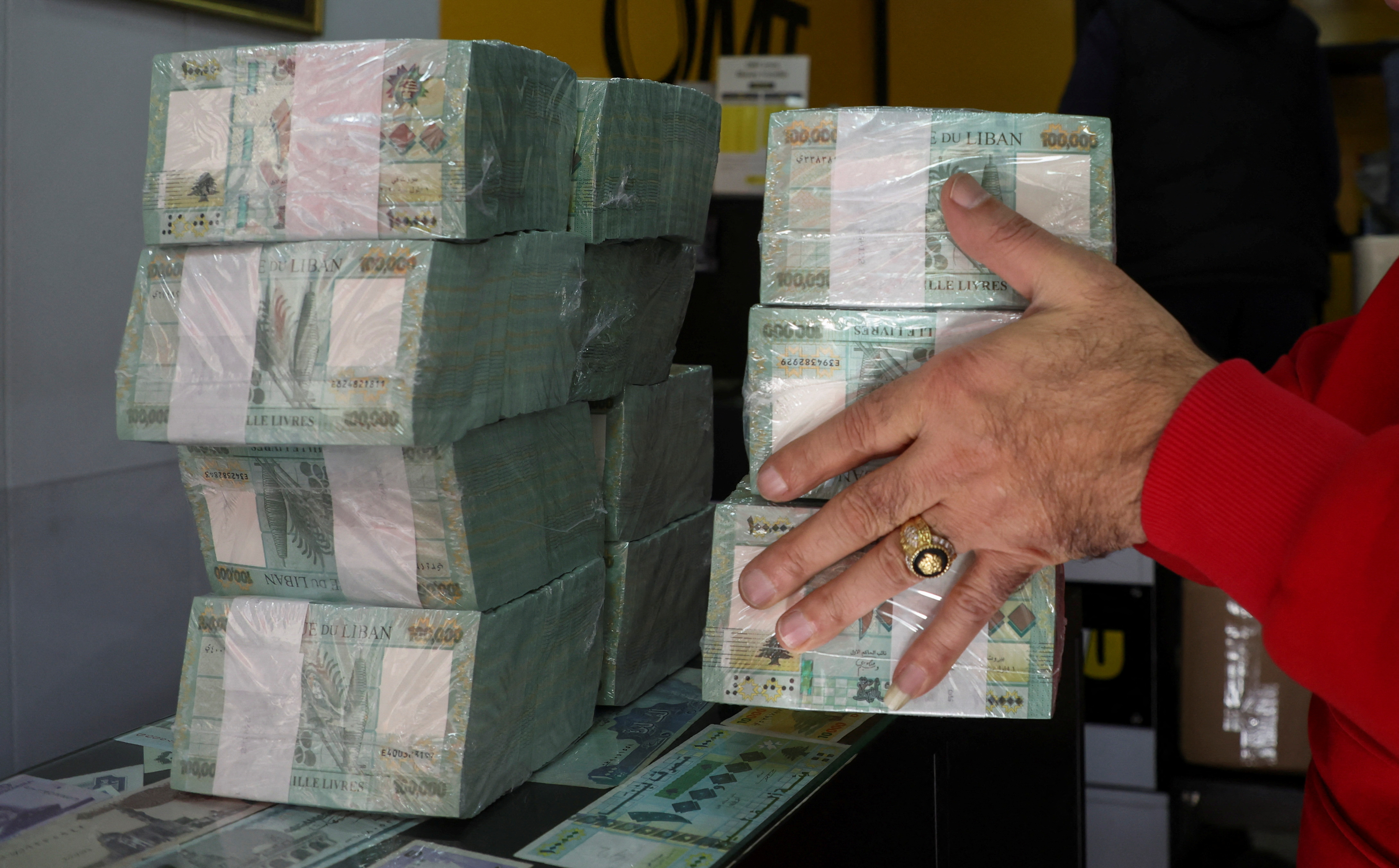 A money exchange vendor holds Lebanese pound banknotes at a shop in Beirut