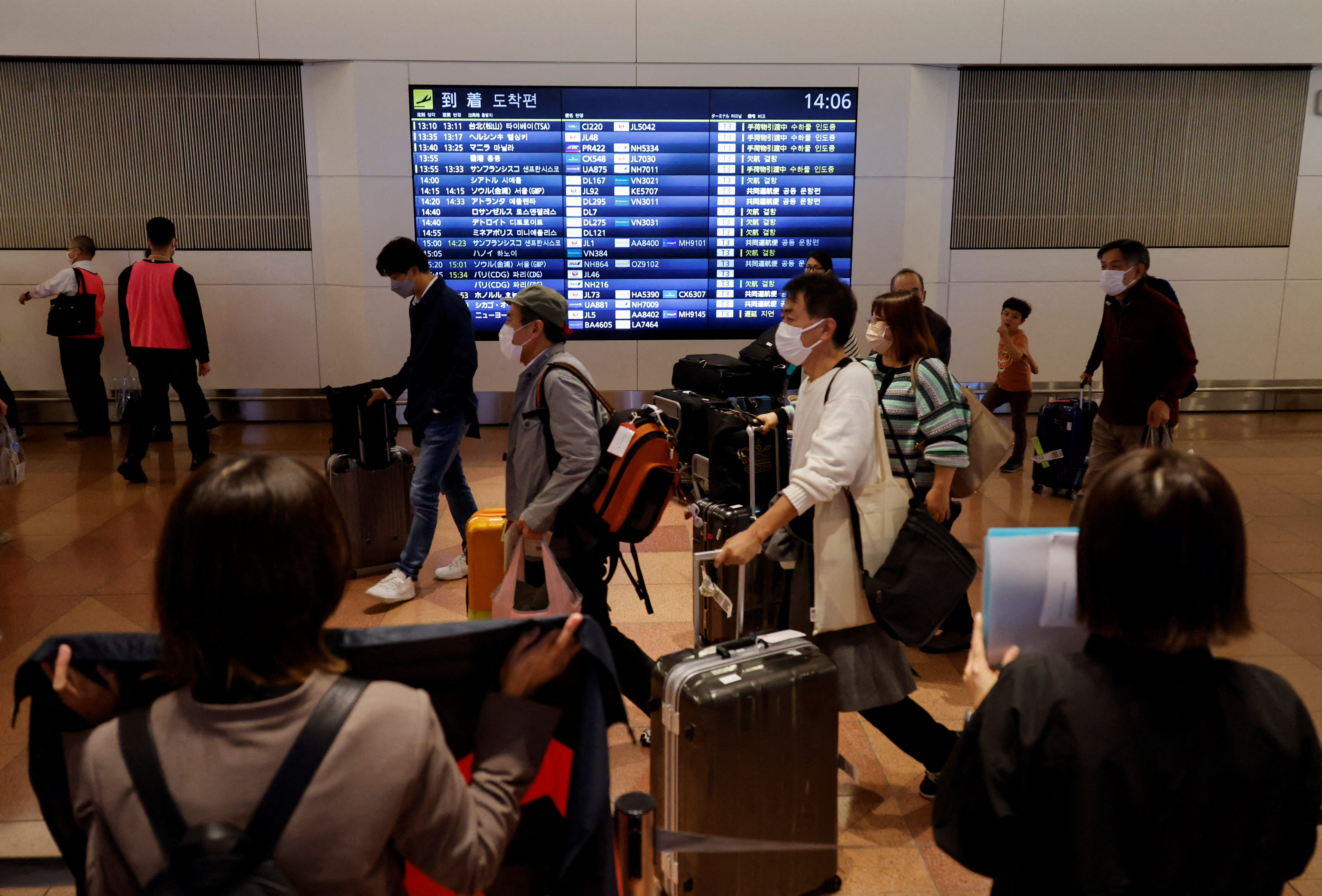 Passengers walk upon their arrival at the Haneda International Airport as Japan reopens for visa-free travel in Tokyo