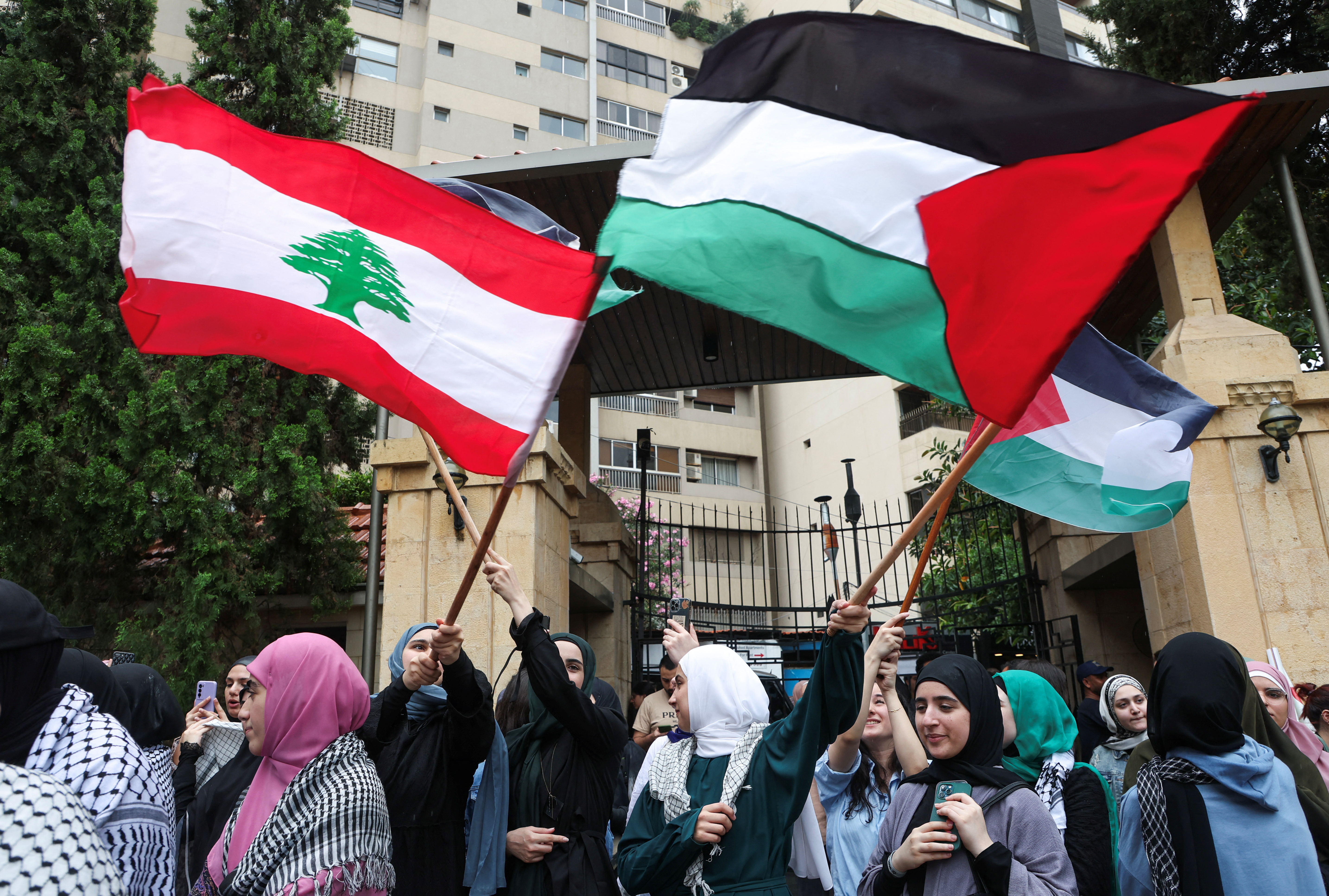 Demonstrators hold Lebanese and Palestinian flags during a protest in solidarity with Gaza at the Lebanese American University (LAU), in Beirut