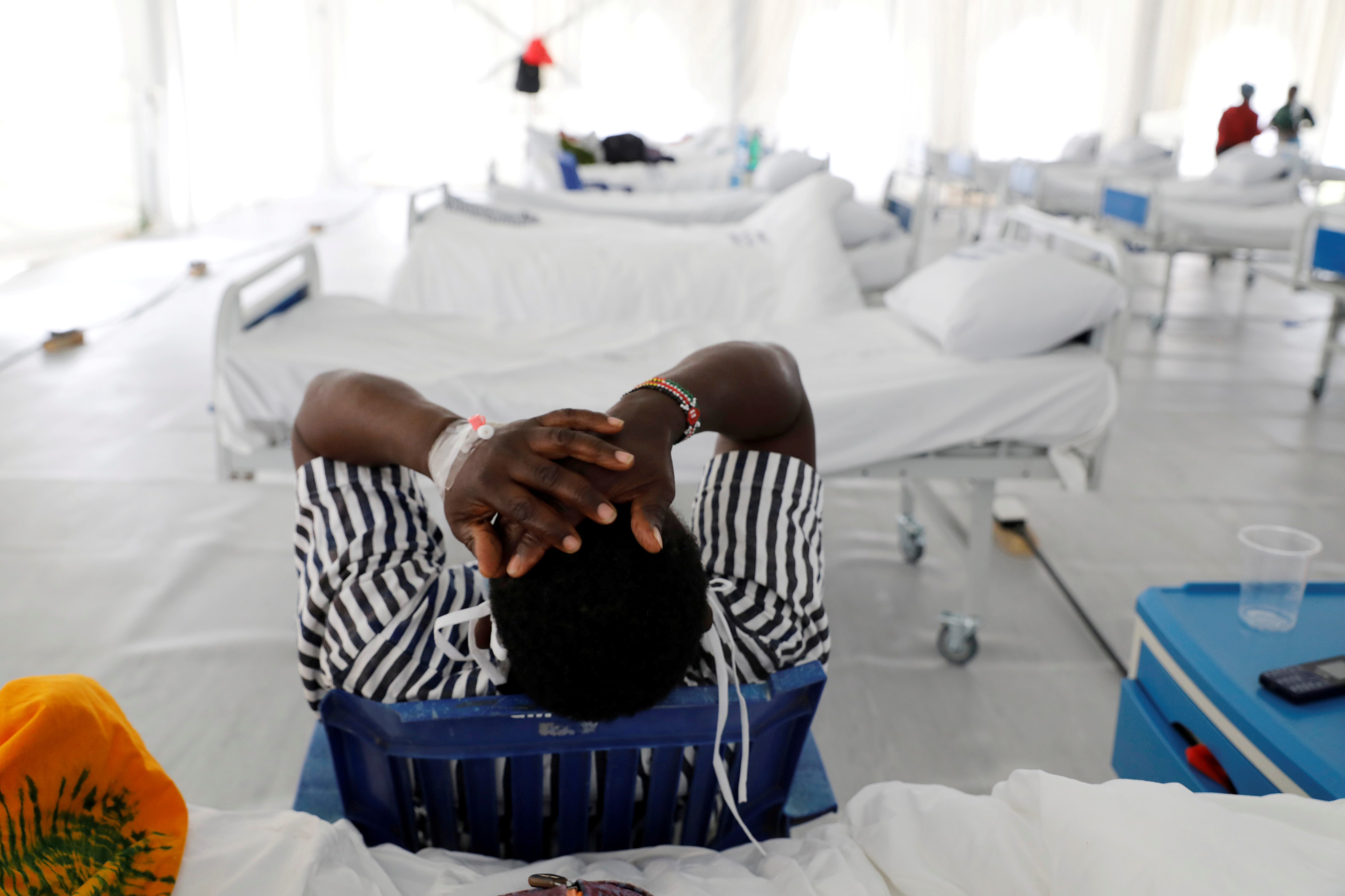 A COVID-19 patient reacts after being tested inside a field hospital built on a soccer stadium in Machakos