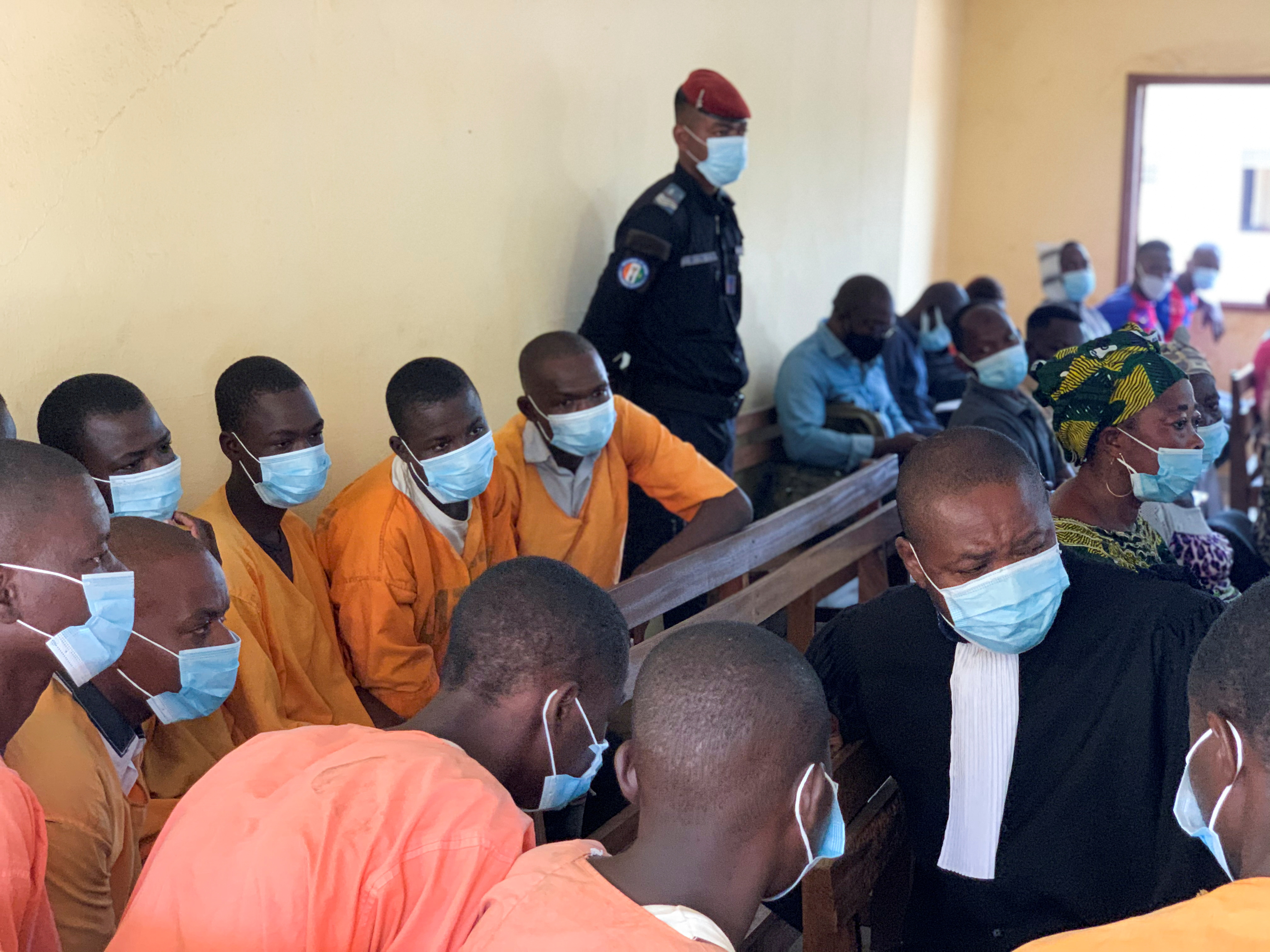 A lawyer speaks to a group of a men accused of child-trafficking at the court in Bouna