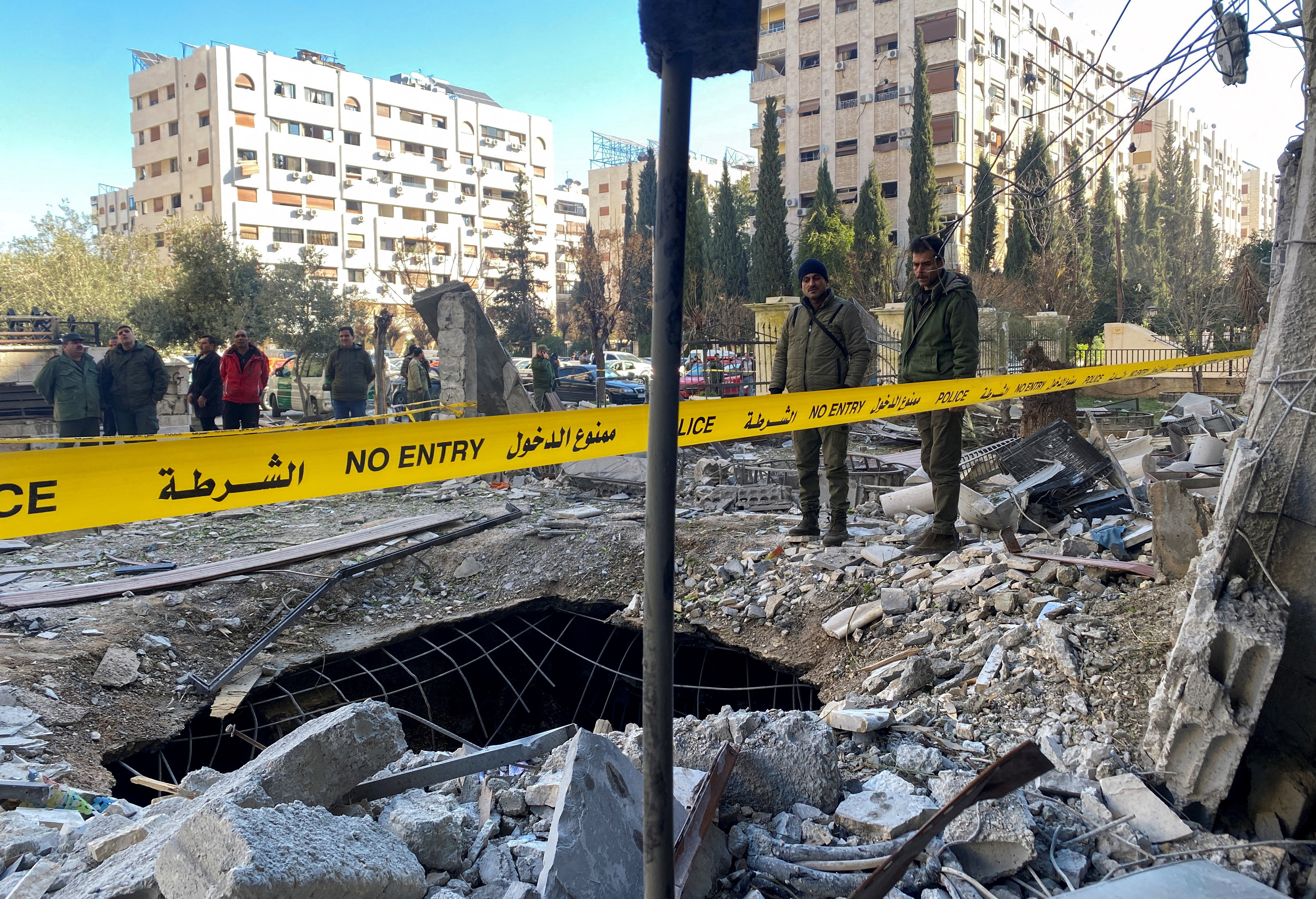Agentes de policía en medio de los escombros de un edificio dañado en el lugar de un ataque con cohetes, en el barrio de Kafr Sousa, en el centro de Damasco.