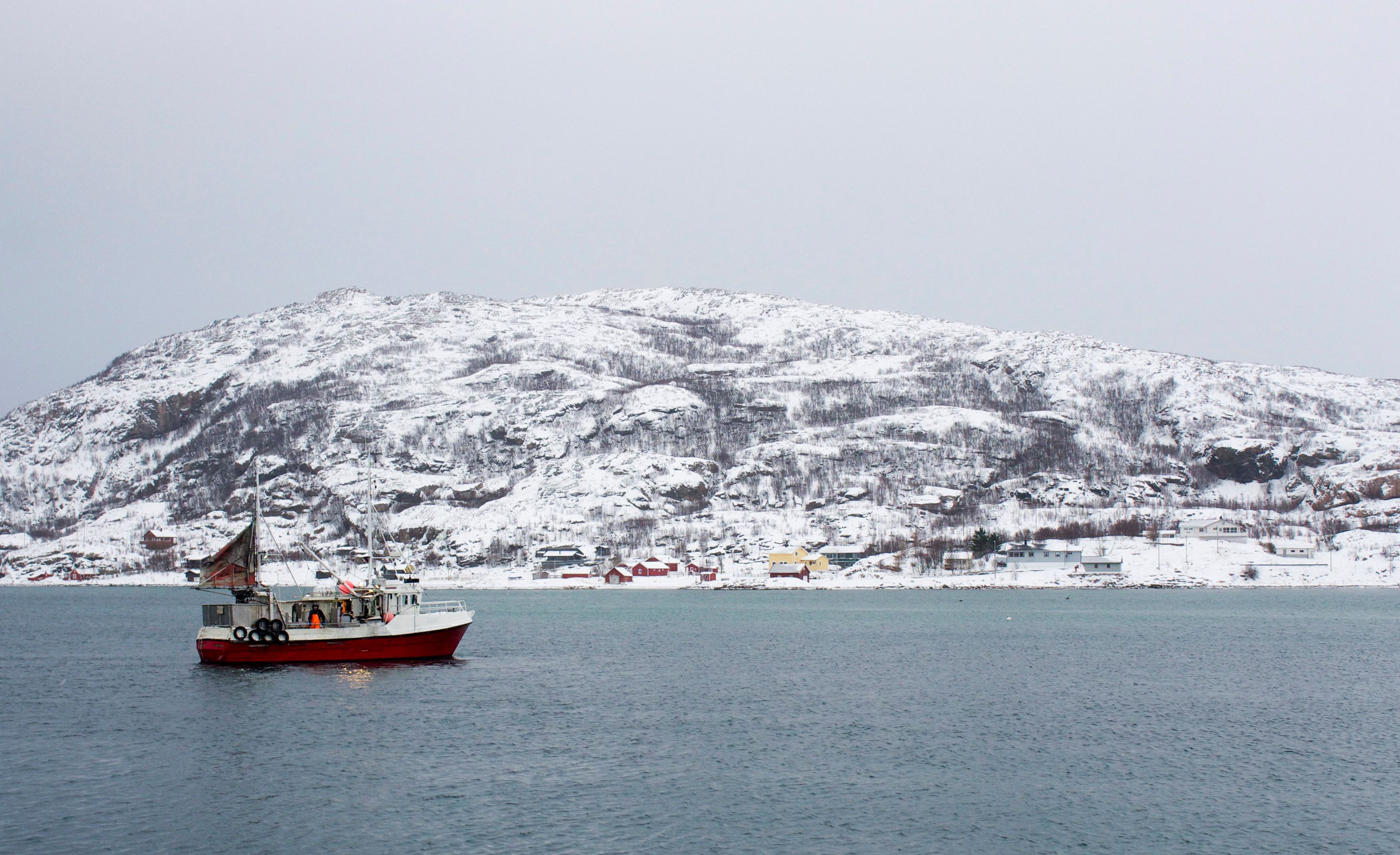 A fishing boat returns from a trip to the Barents Sea to the tiny port of Sommaroya