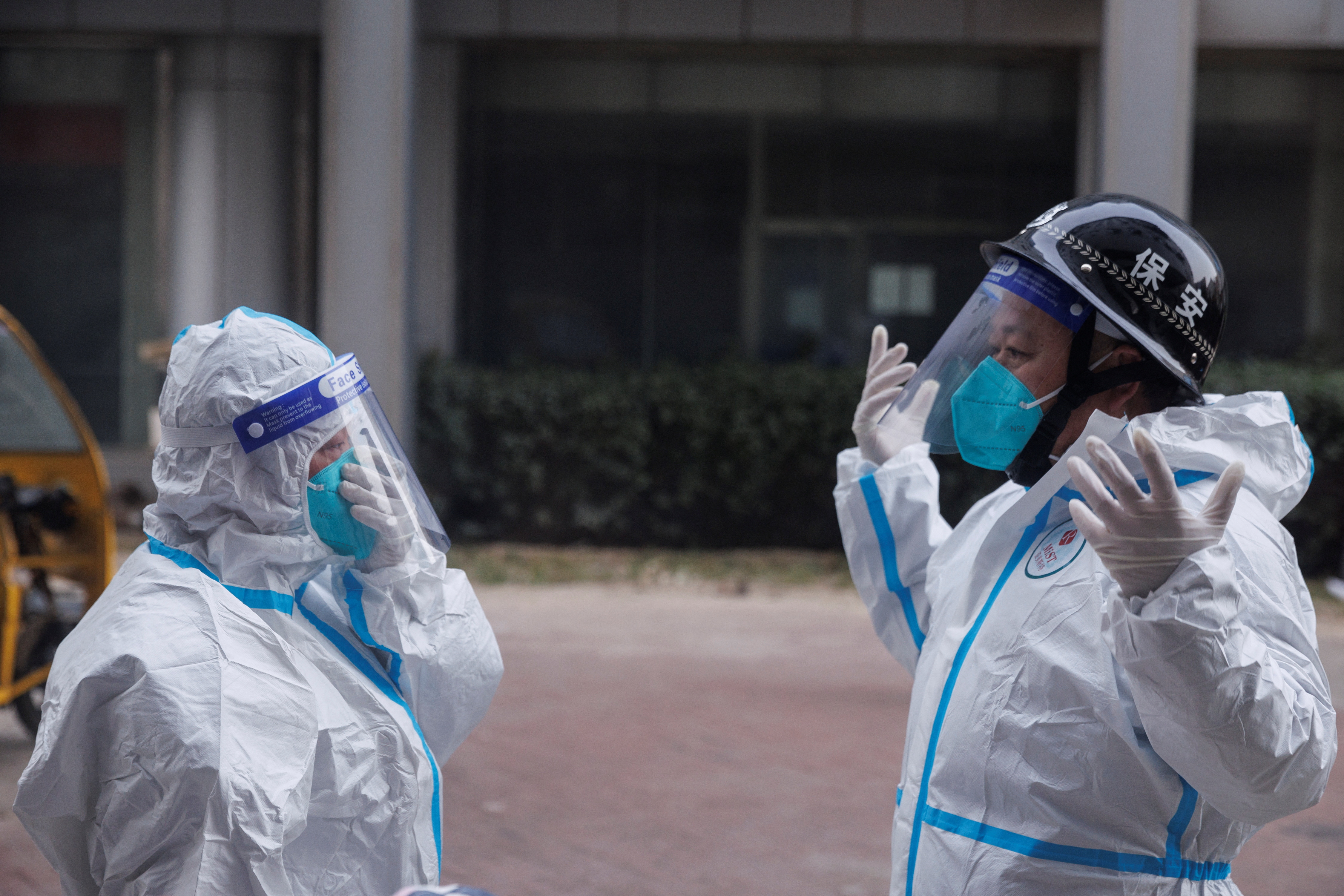 Pandemic prevention workers in protective suits get ready to enter an apartment building that went into lockdown as coronavirus disease (COVID-19) outbreaks continue in Beijing