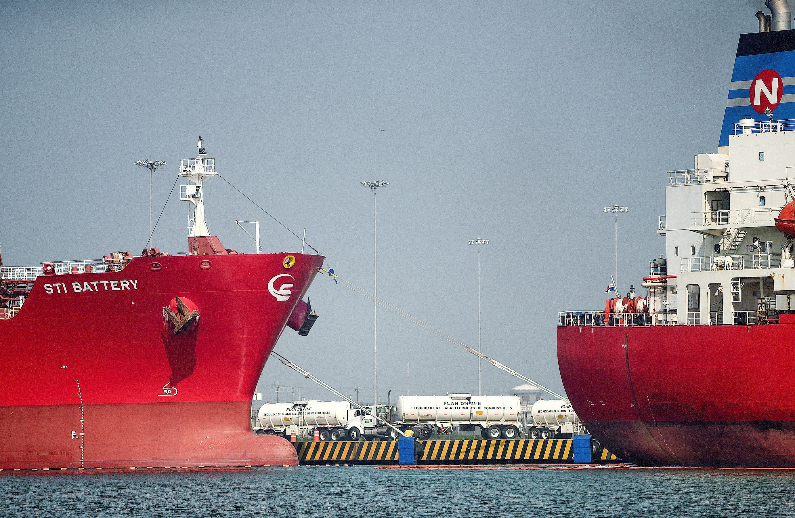 Tanker trucks are seen among oil tankers docked at the port of Tuxpan