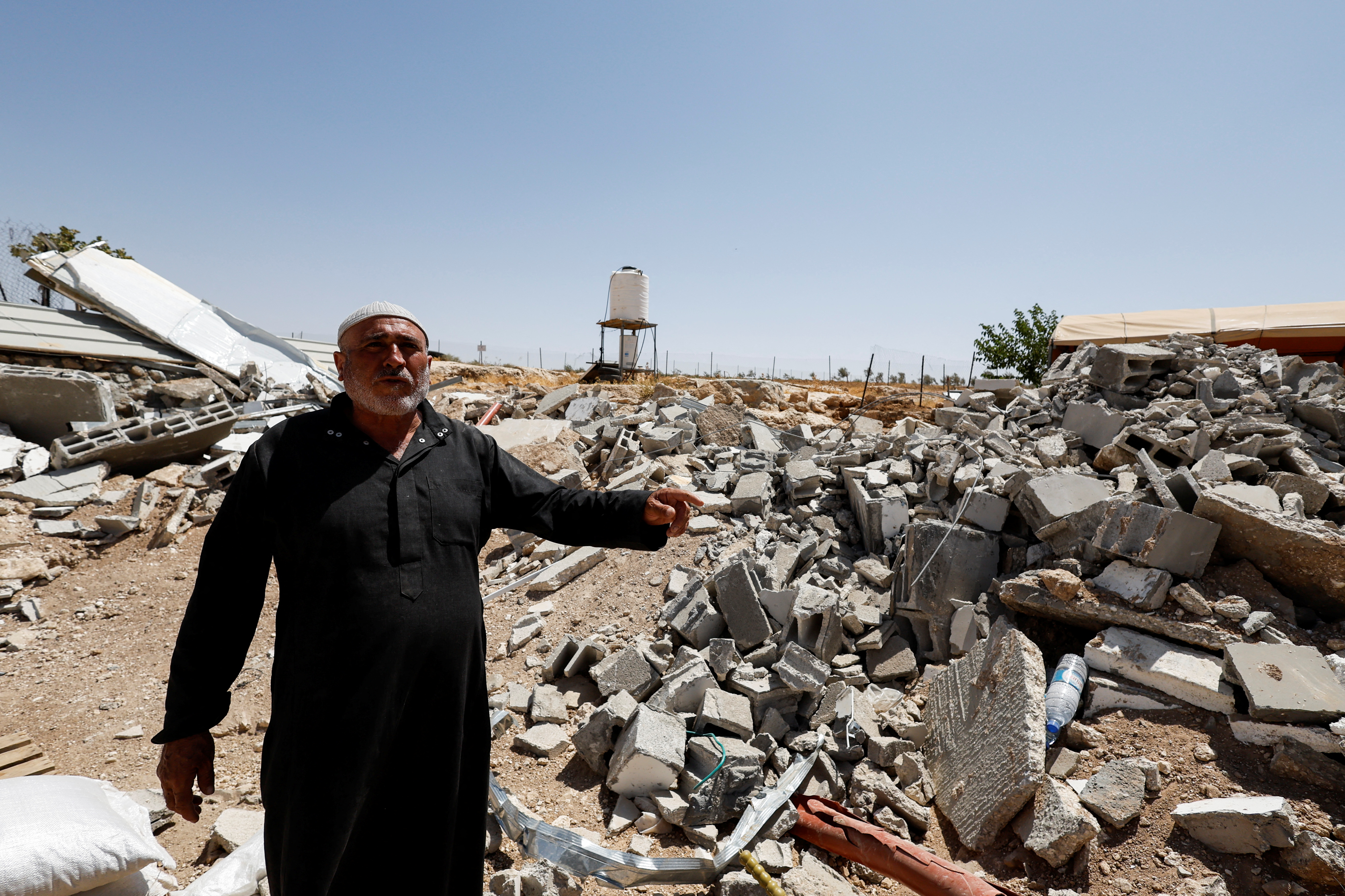 Palestinian Mahmoud Najajreh points at his demolished house, in Masafer Yatta
