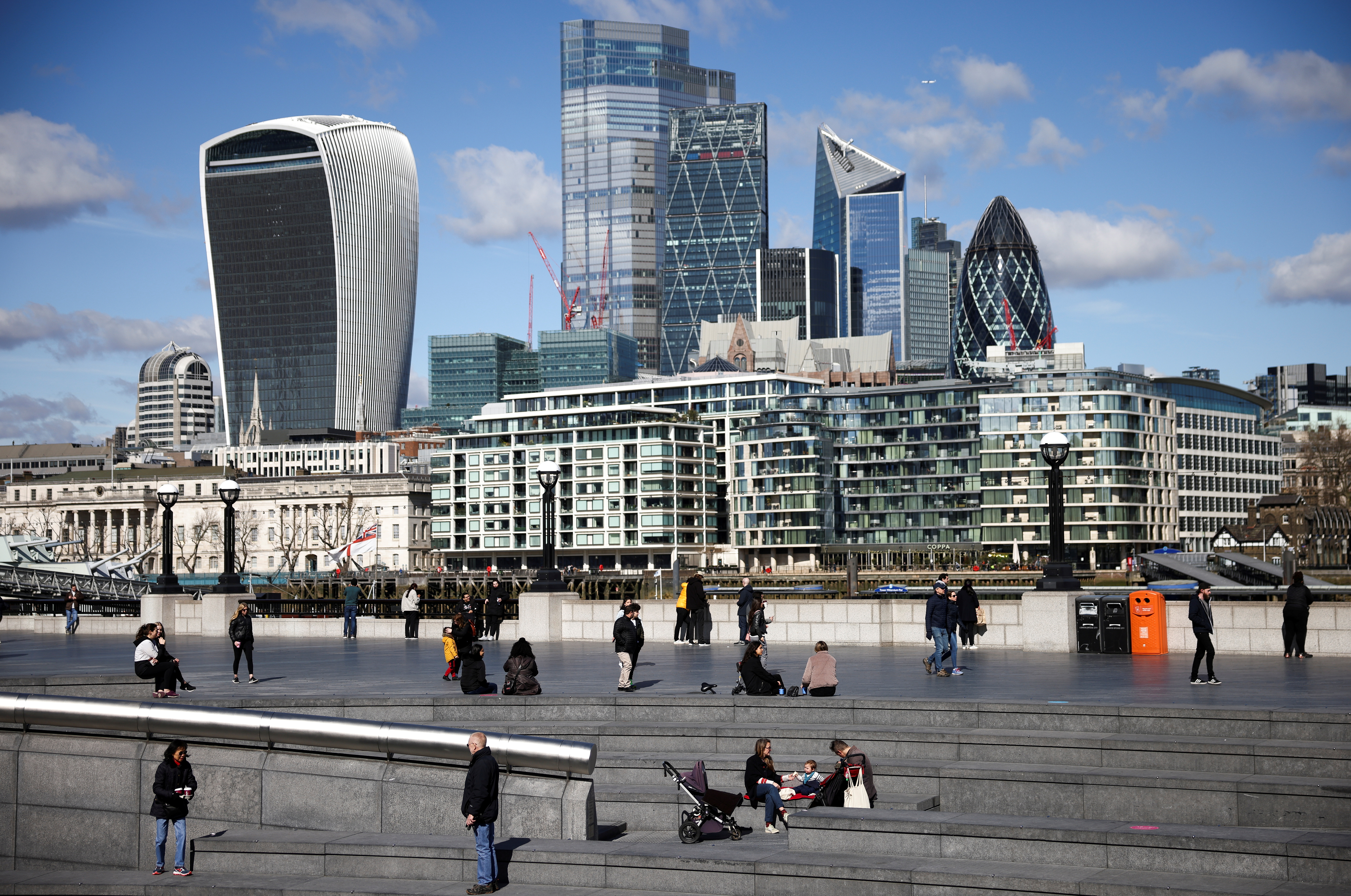 The City of London financial district can be seen as people walk along the south side of the River Thames amid the coronavirus disease (COVID-19) outbreak in London