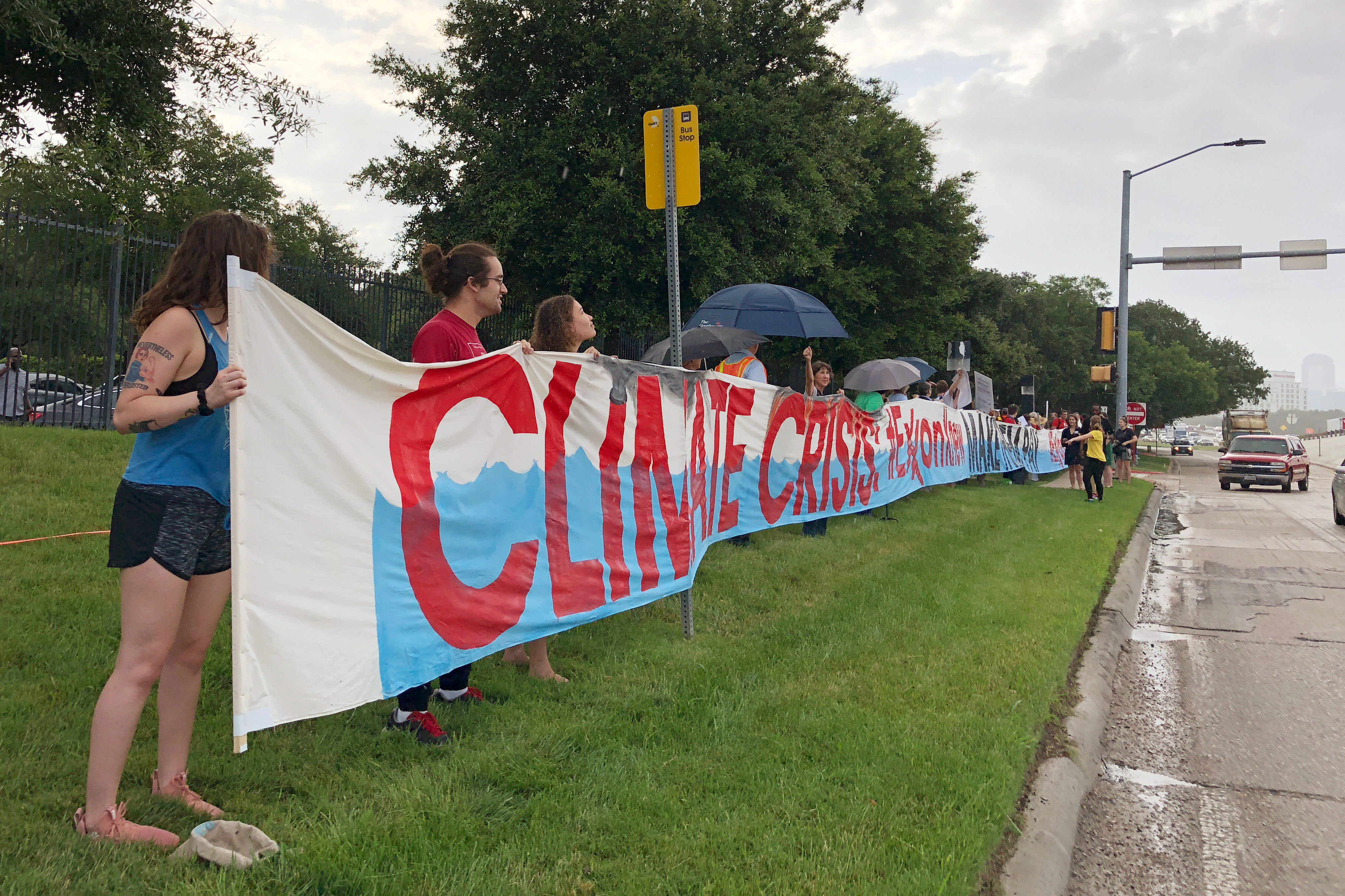 Protestors gather outside the ExxonMobil annual shareholders meeting to protest the company’s climate policies as people arrive at the 2019 annual shareholders meeting in Dallas