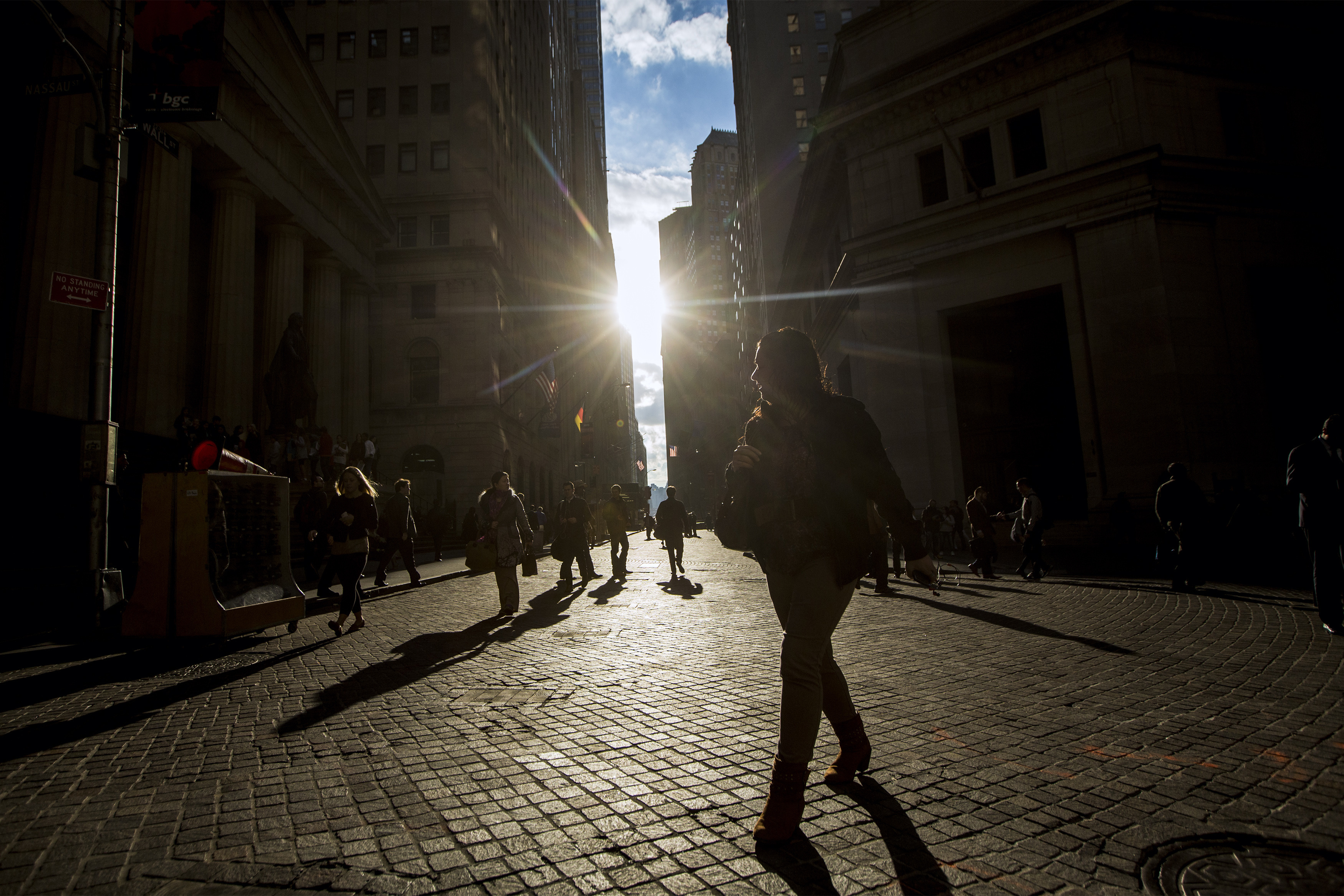 Morning commuters walk on Wall Street in New York's financial district
