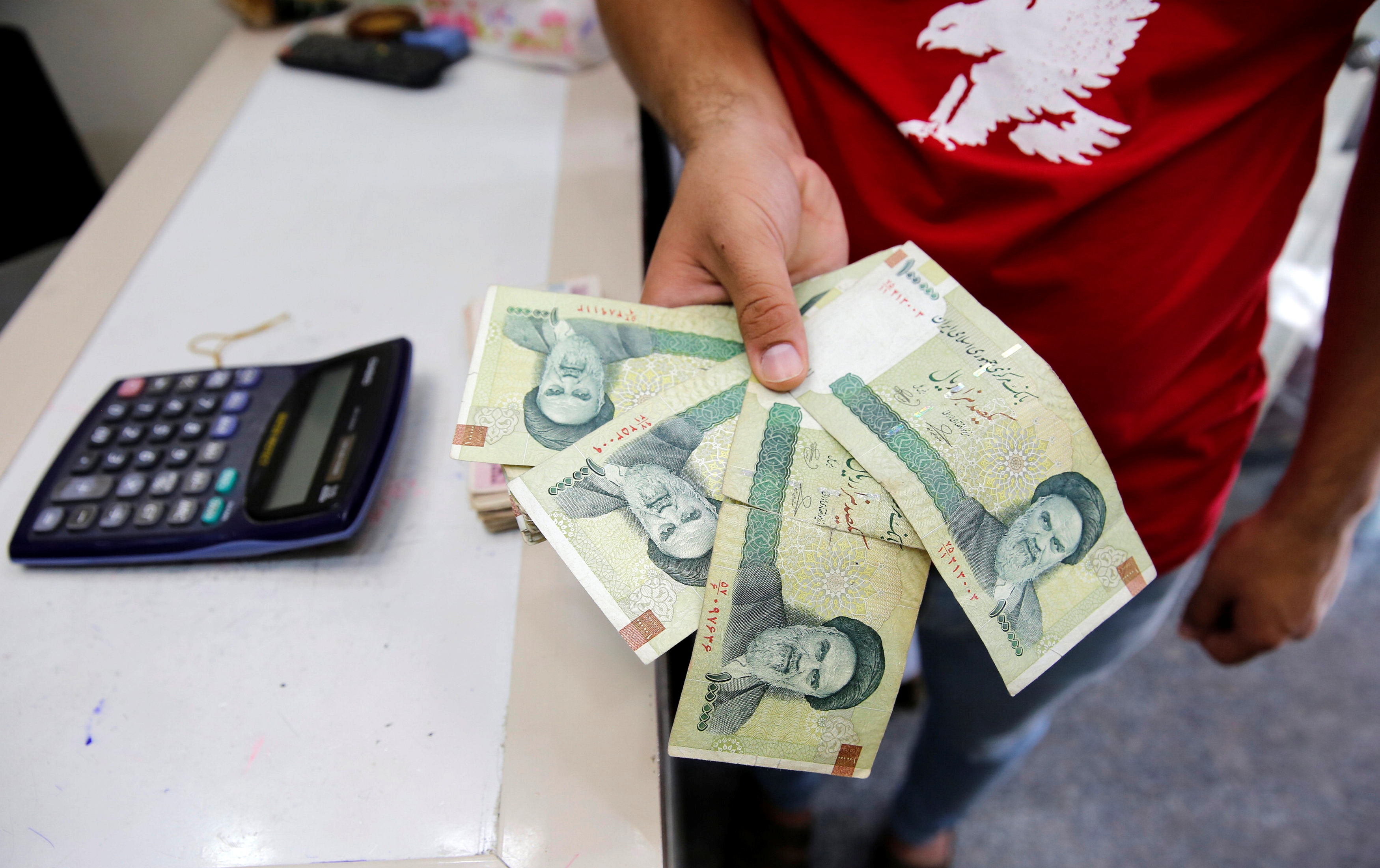 A vendor inspects Iranian rials at a currency exchange shop in Baghdad, Iraq August 8, 2018. REUTERS/Khalid Al-Mousily