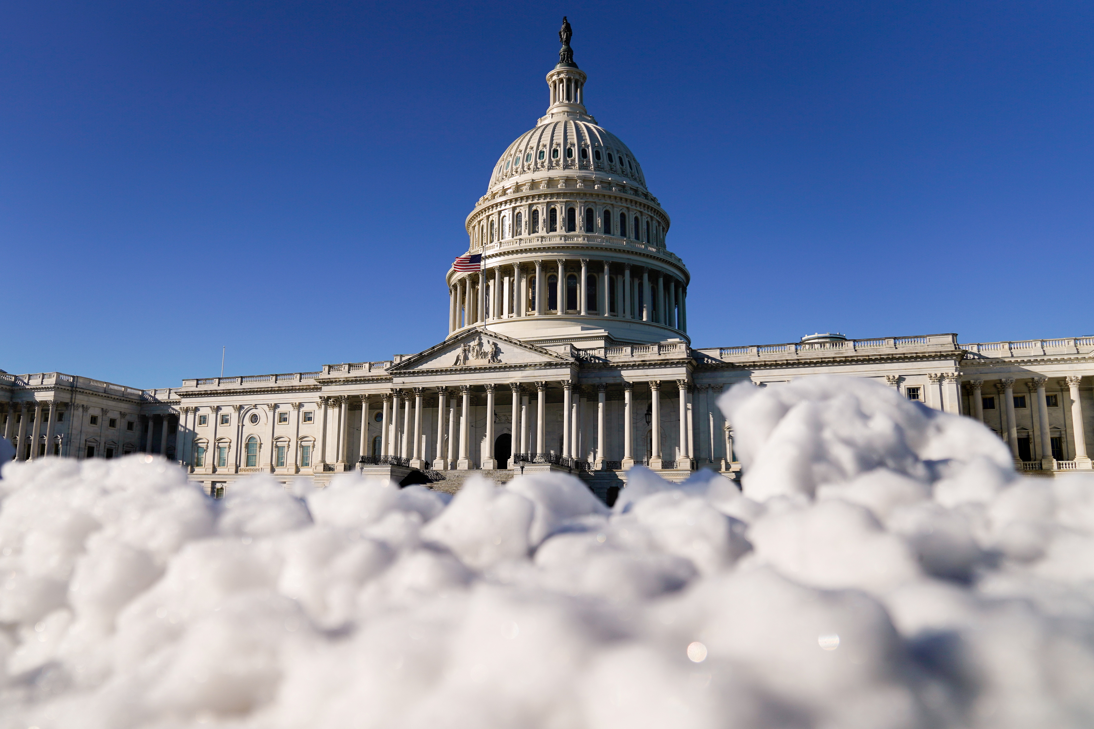 The U.S. Capitol is seen behind melting snow in Washington
