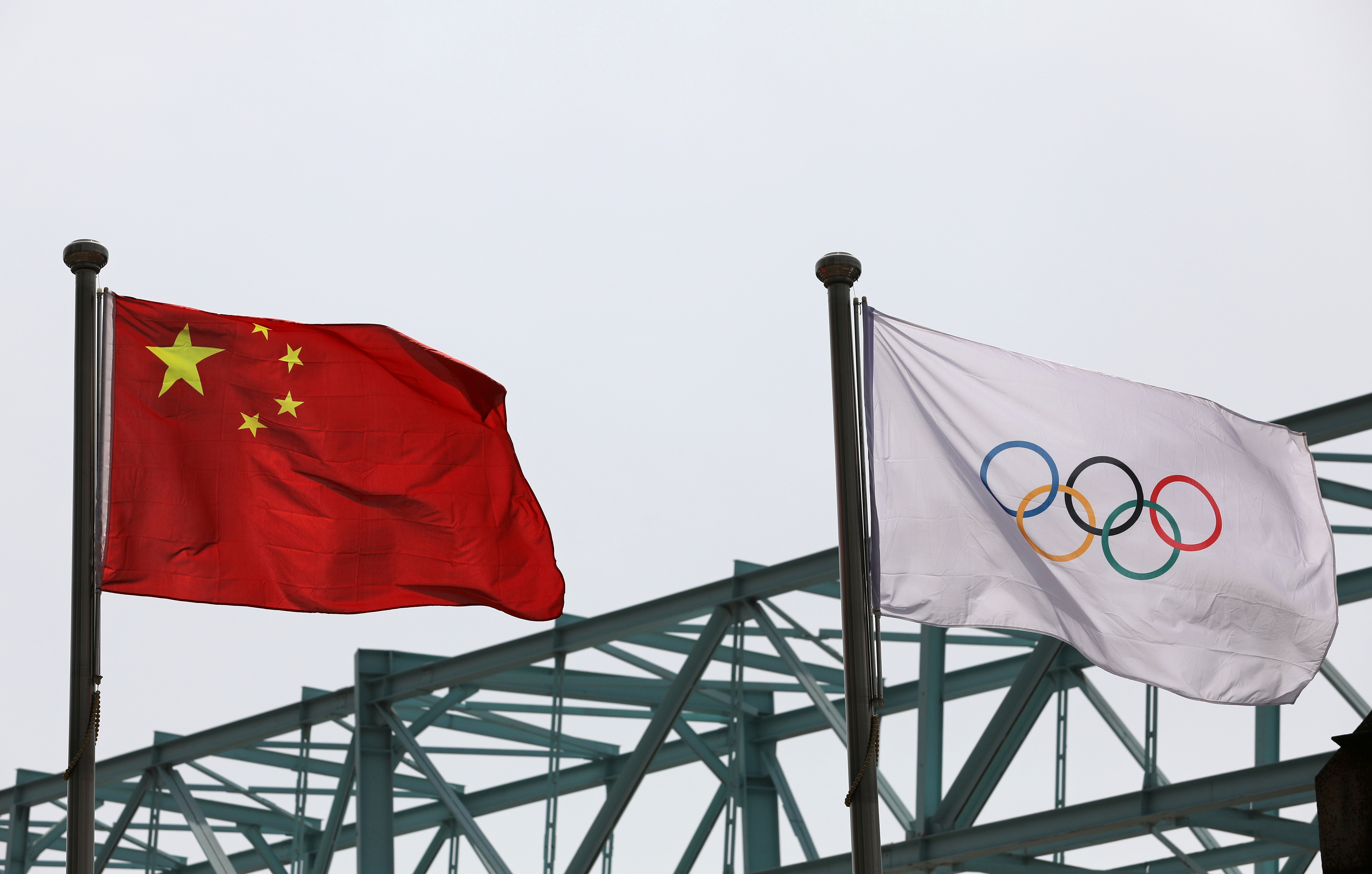 Chinese national flag flutters next to an Olympic flag at the Beijing Organising Committee for the 2022 Olympic and Paralympic Winter Games, in Beijing