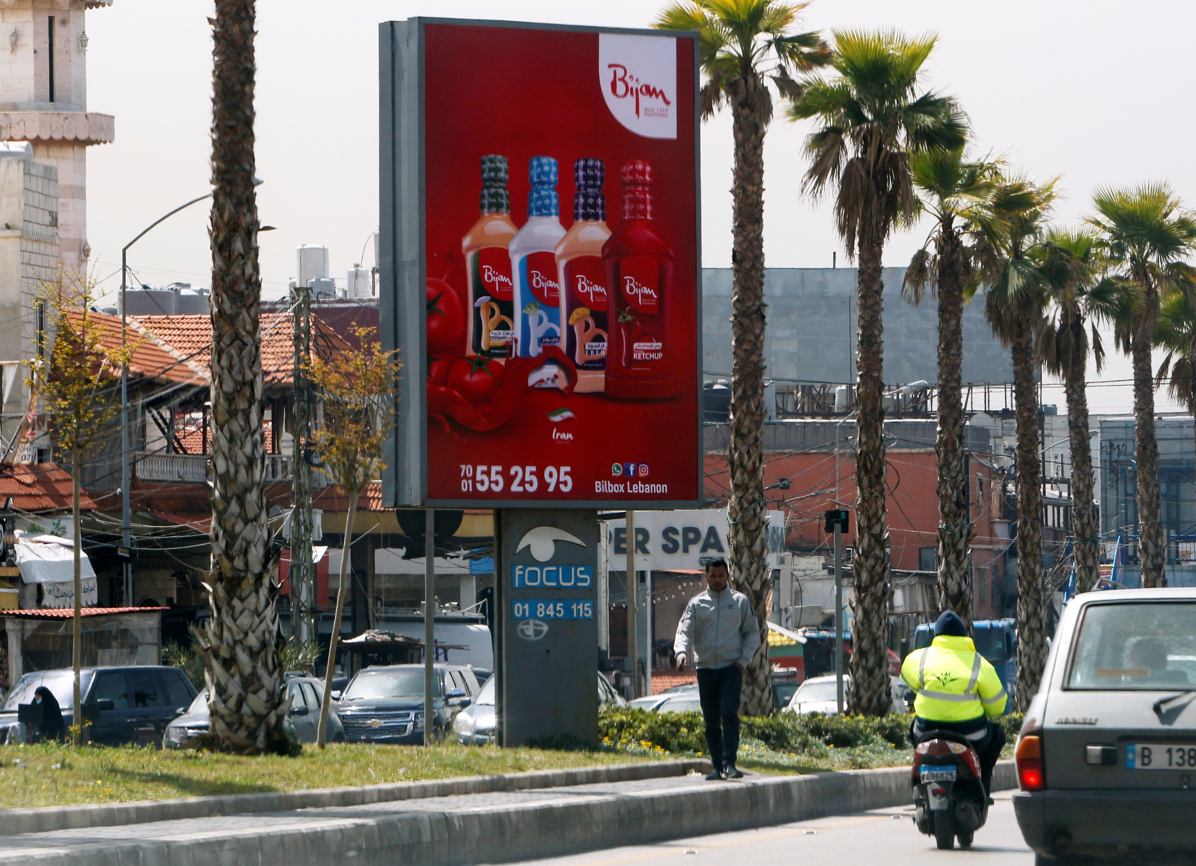Man walks past an advertising billboard in Beirut suburbs